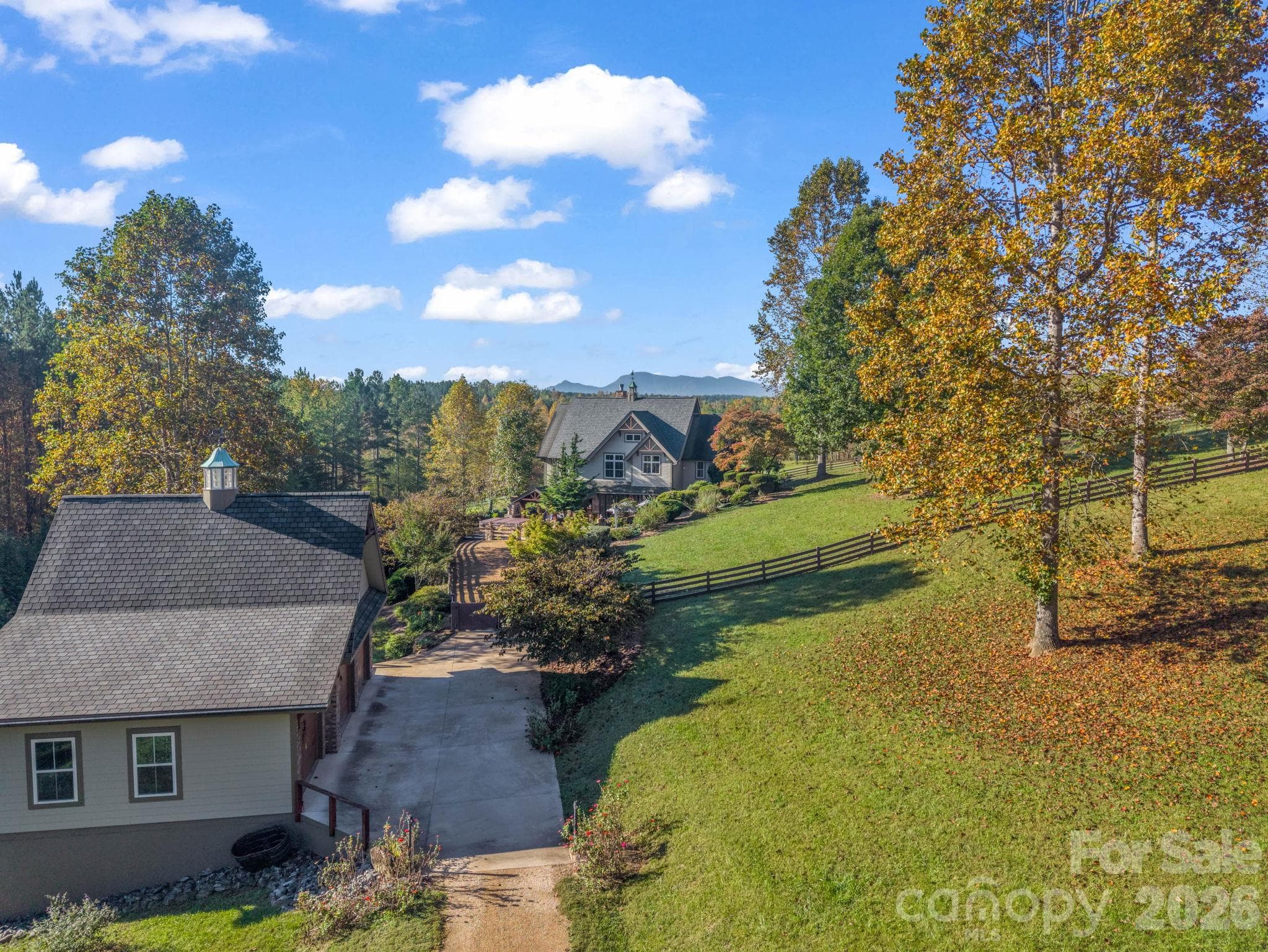 Private drive, 3-car garage to the left, mountain views from the rear of the home and both primary bedrooms, and living room/kitchen - 140 Blazing Star Lane, Mill Spring