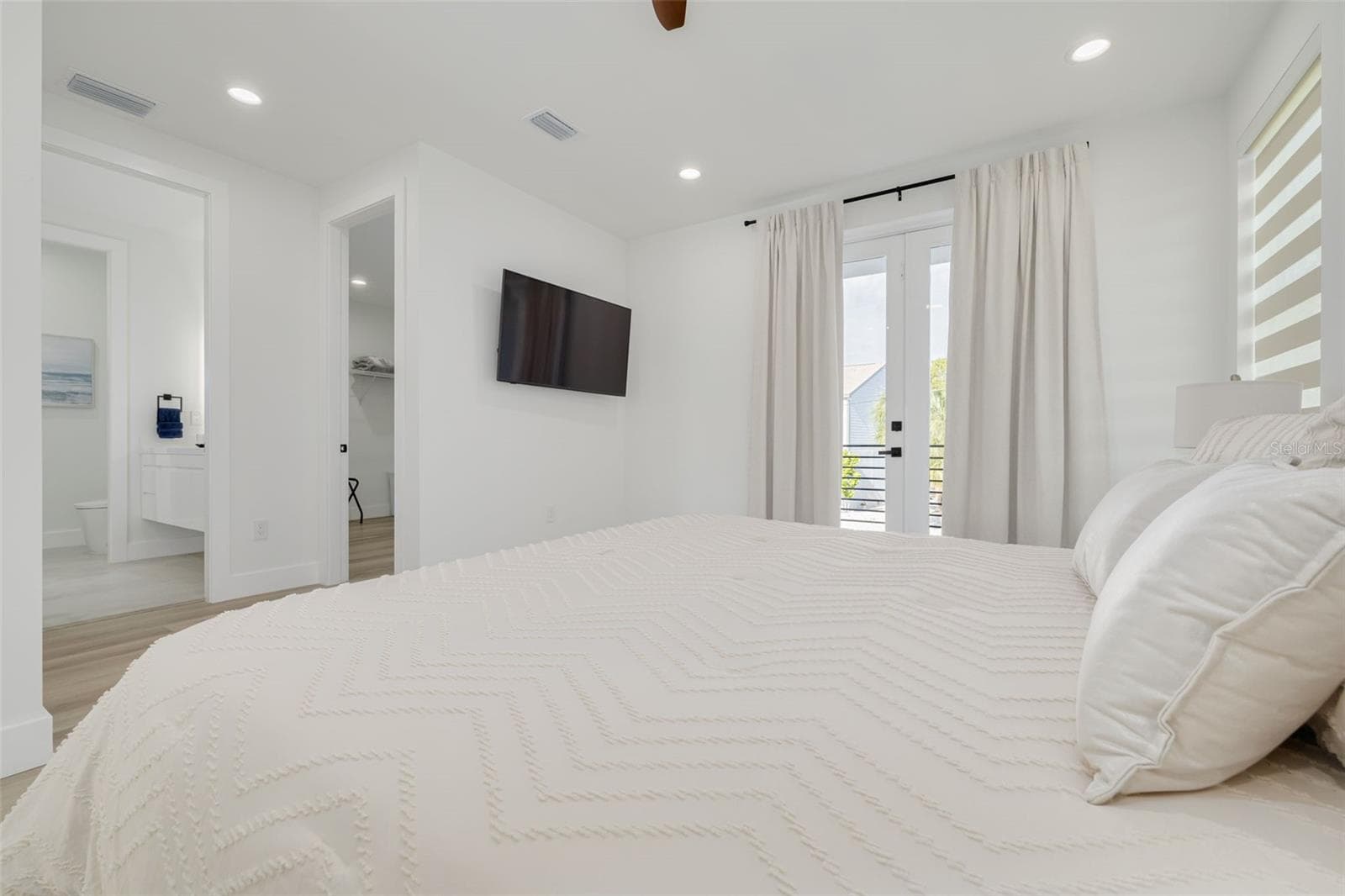 Bedroom with balcony and an ensuite on the main living floor. - 7609 DEEDRA CIR, PORT RICHEY