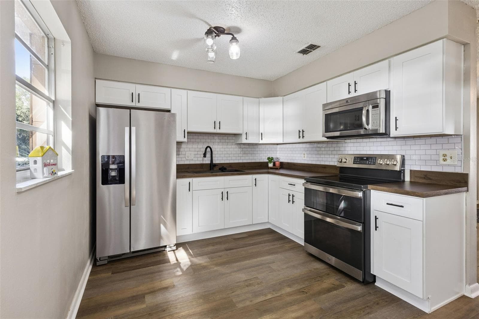 Kitchen updated with newer cabinets and appliances. - 416 WINNERS CIR, LADY LAKE