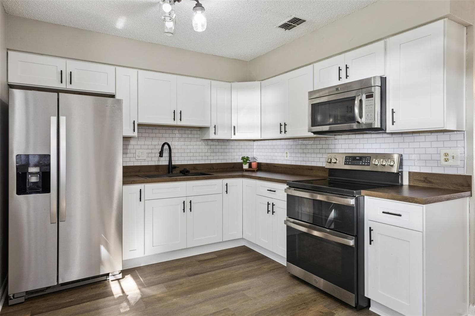 Kitchen has newer cabinets, counter, sink, faucet and appliances! - 416 WINNERS CIR, LADY LAKE