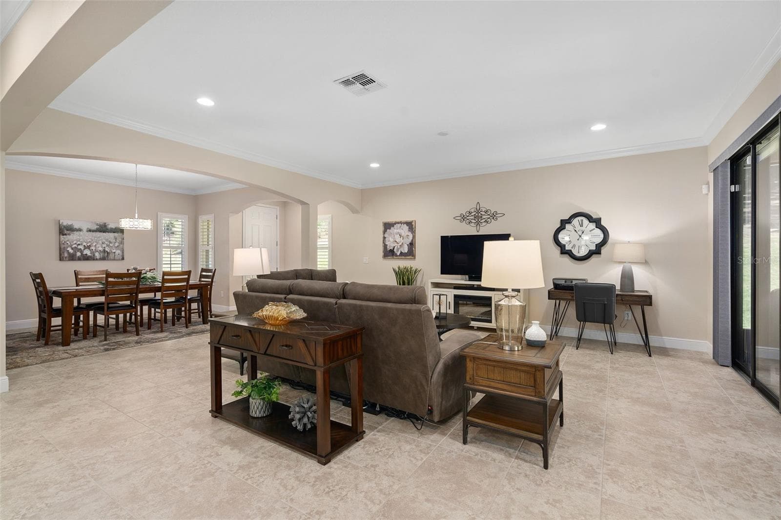 Family and Dining Rooms featuring Architectural Arches and Upgraded Ceramic Tile flooring. There is a Floor Electrical Receptacle in the Family Room for your convenience. - 2607 CLEMSON RIDGE CT, CLERMONT