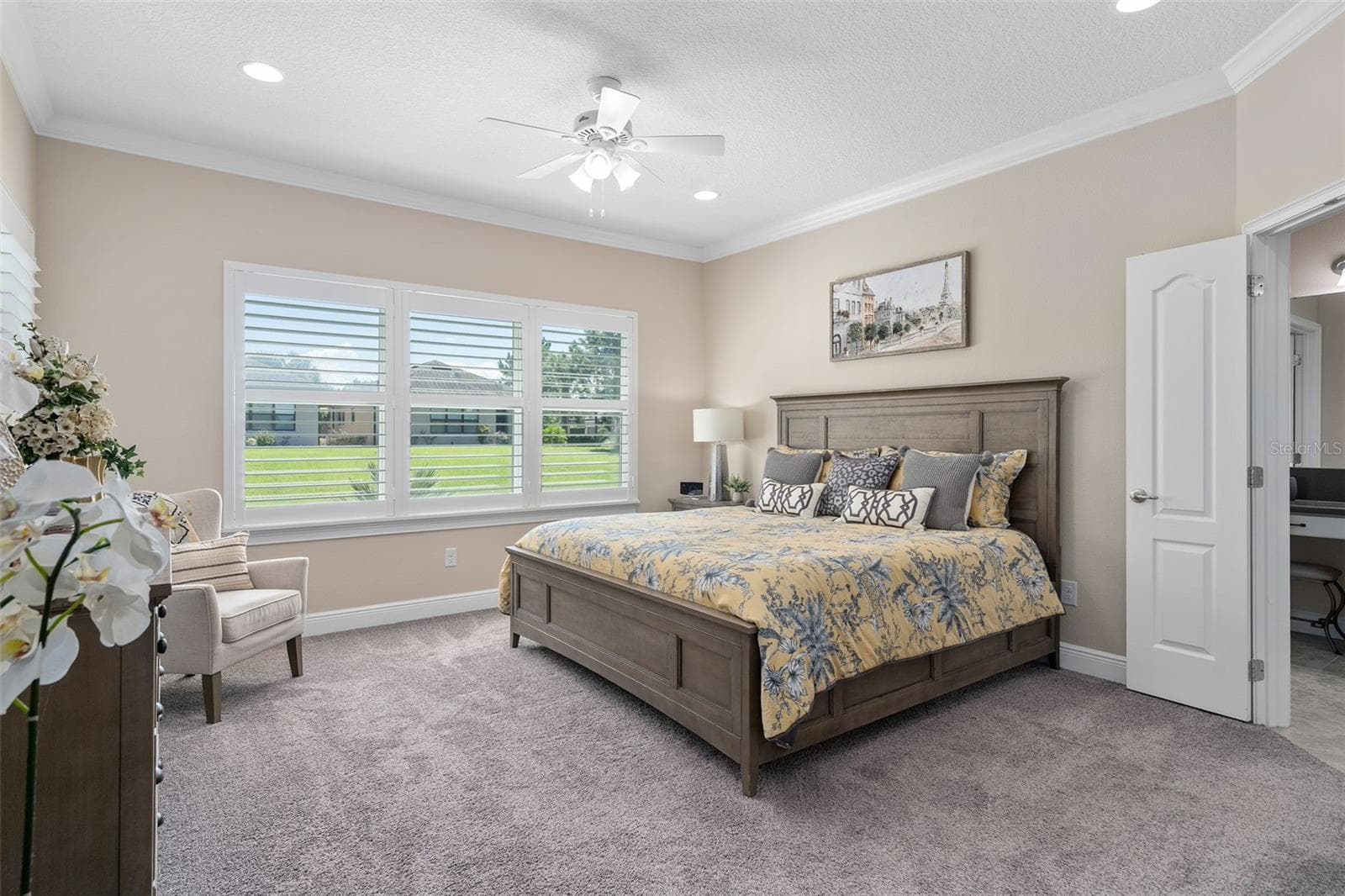 Primary Bedroom is spacious offering great natural light, Plantation Shutters, additional ceiling lighting plus a fan, Crown Molding, Walk-in Custom Organized Closet and a great En-Suite. - 2607 CLEMSON RIDGE CT, CLERMONT