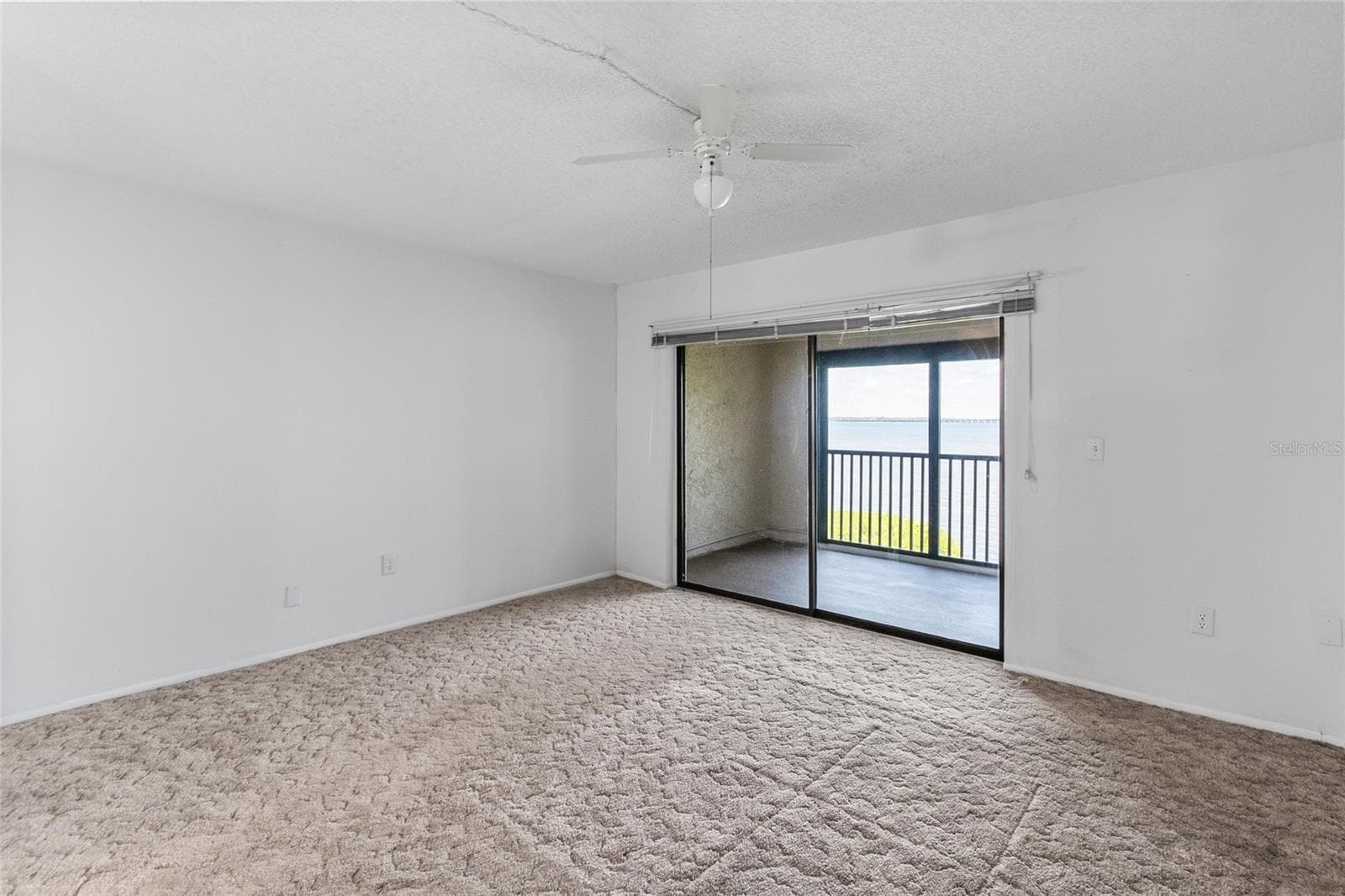 Primary bedroom - looking towards the private balcony with panoramic water views. - 2980 HAINES BAYSHORE RD #105, CLEARWATER