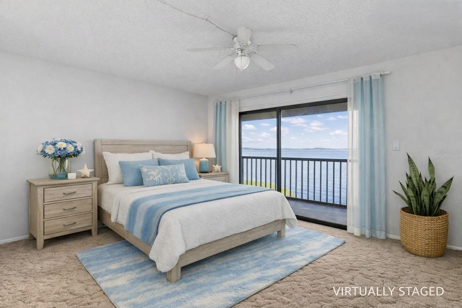 Virtually staged primary bedroom looking towards the balcony and fully panoramic water views. - 2980 HAINES BAYSHORE RD #105, CLEARWATER