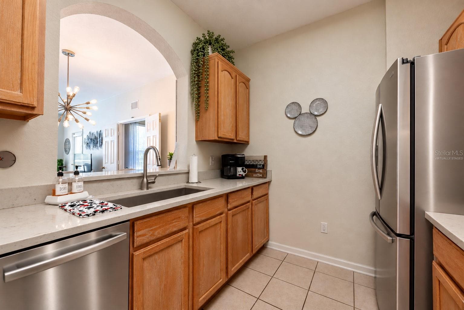 Photos cannot convey the beautifully refininished solid, light, washed oak cabinets and the updated classy quartz countertops. <Virtually staged with stainless steel appliances to show that alternative option for buyers>. - 2778 ALMATON LOOP #204, KISSIMMEE