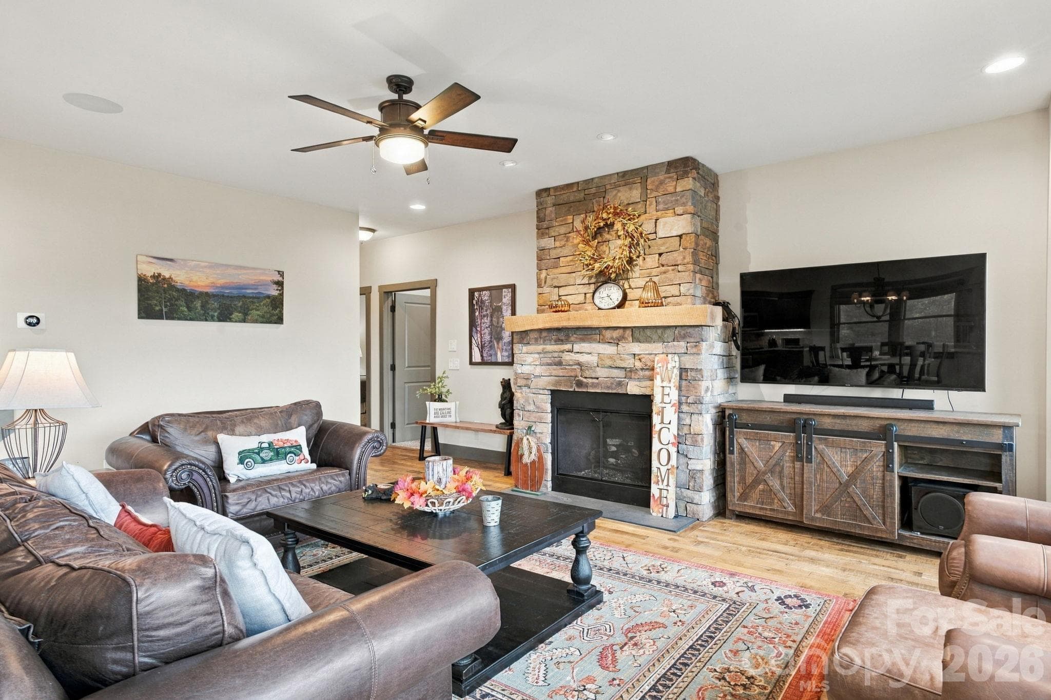 Living room with stone fireplace and ceiling fan - 1206 River Stone Drive, Laurel Springs