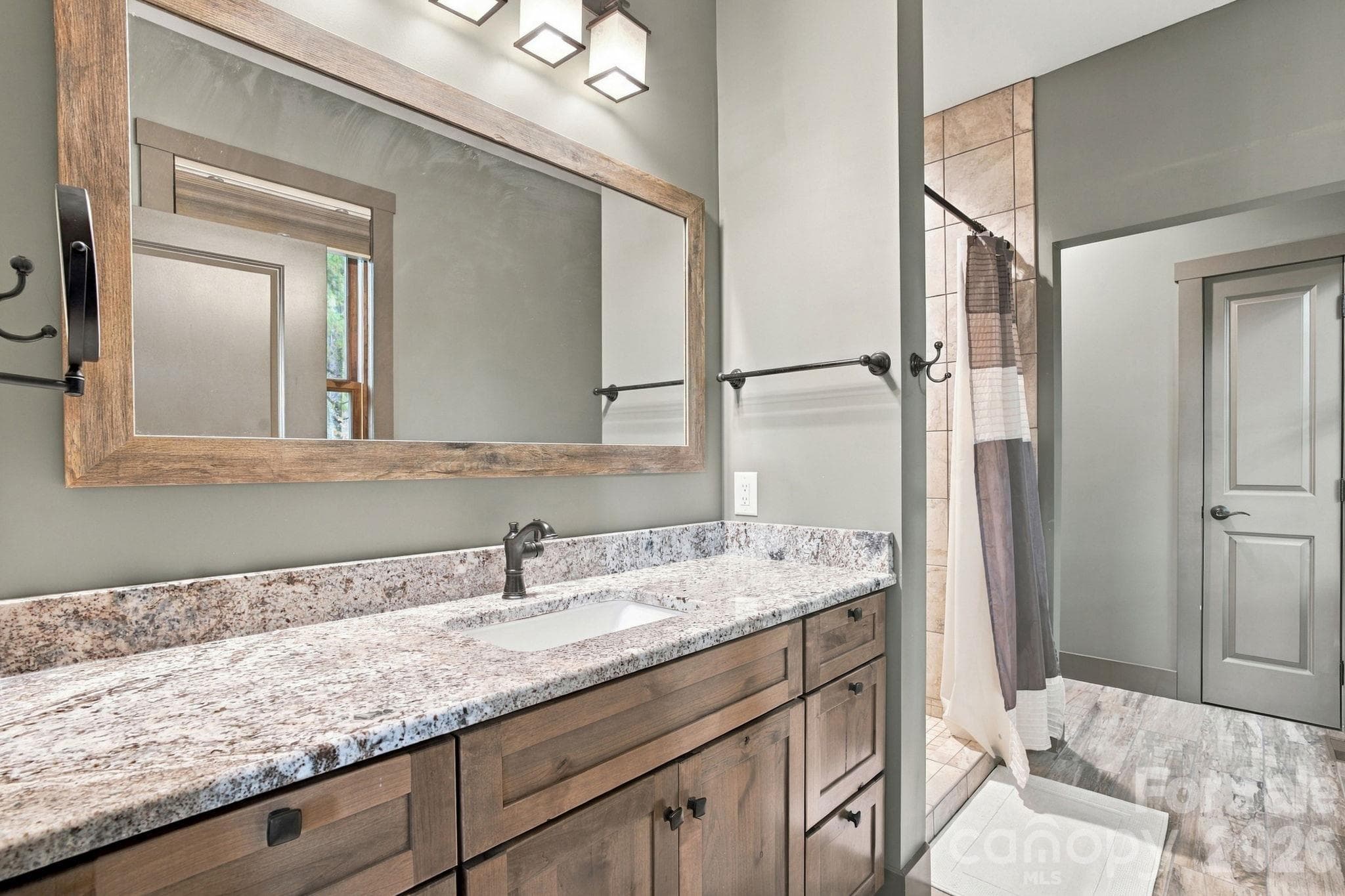 Primary bathroom with granite vanity and tiled shower with linen closet - 1206 River Stone Drive, Laurel Springs