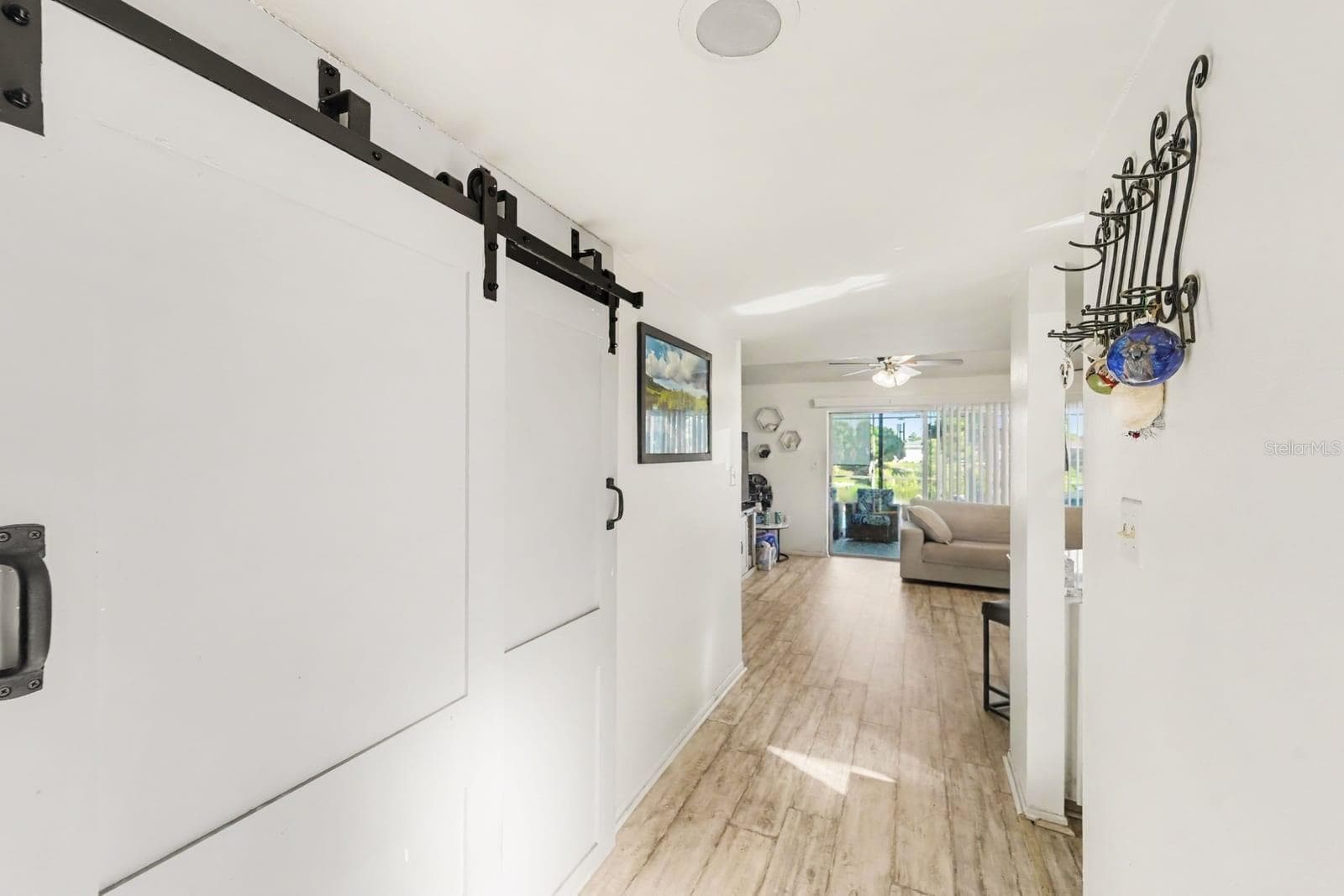 Bright entry hallway with barn door and wood-look flooring - 8431 REDFIELD DR, PORT RICHEY