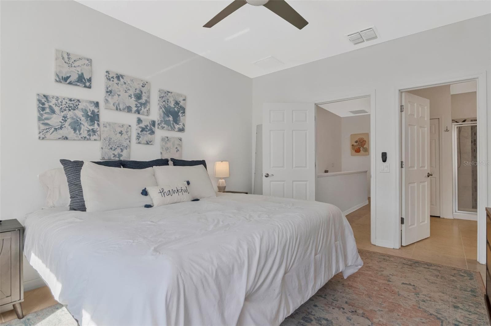 Spacious primary bedroom filled with natural light, featuring an en-suite bathroom and double closets. - 2455 GOLDEN PASTURE CIR, CLEARWATER