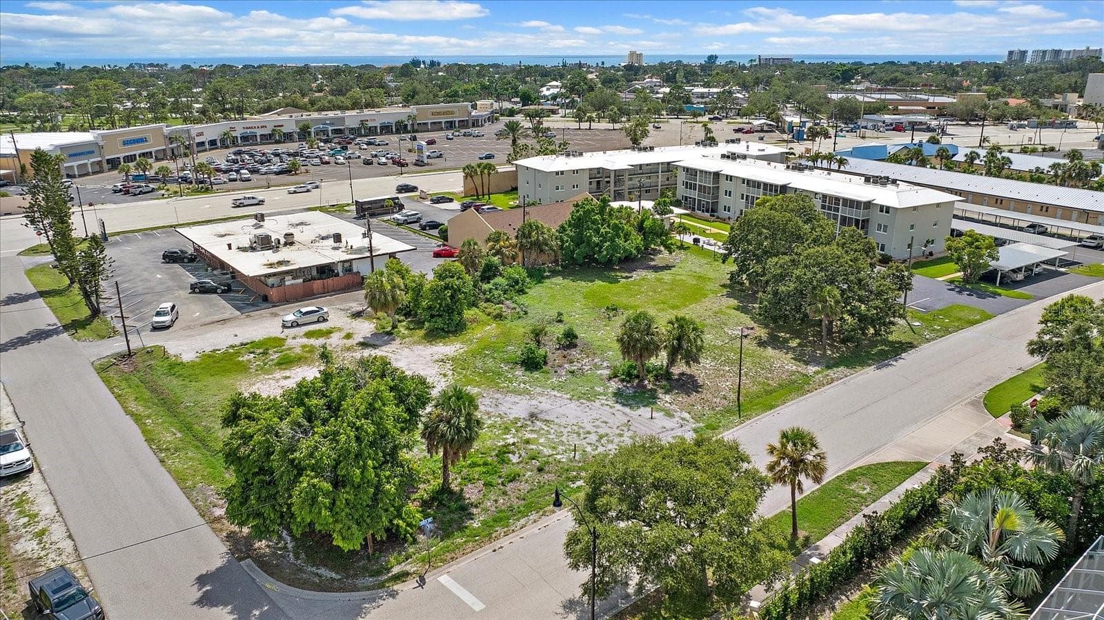 Aerial view of the lot facing the shopping plaza and nearby condominiums - 648 GUILD DR, VENICE