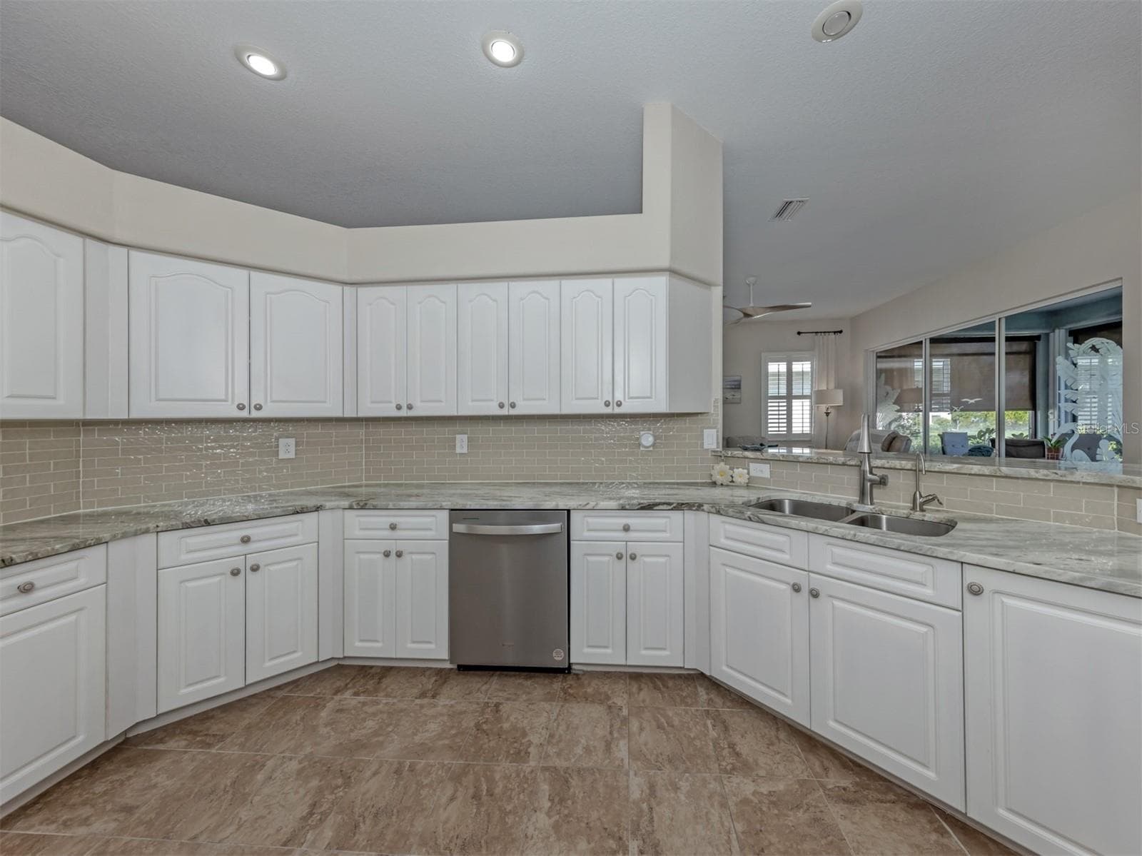 Crisp white cabinetry brings a fresh, timeless elegance to the kitchen, offering plenty of storage while beautifully complementing the rich granite countertops! - 443 BERMUDA ISLES CIR, VENICE