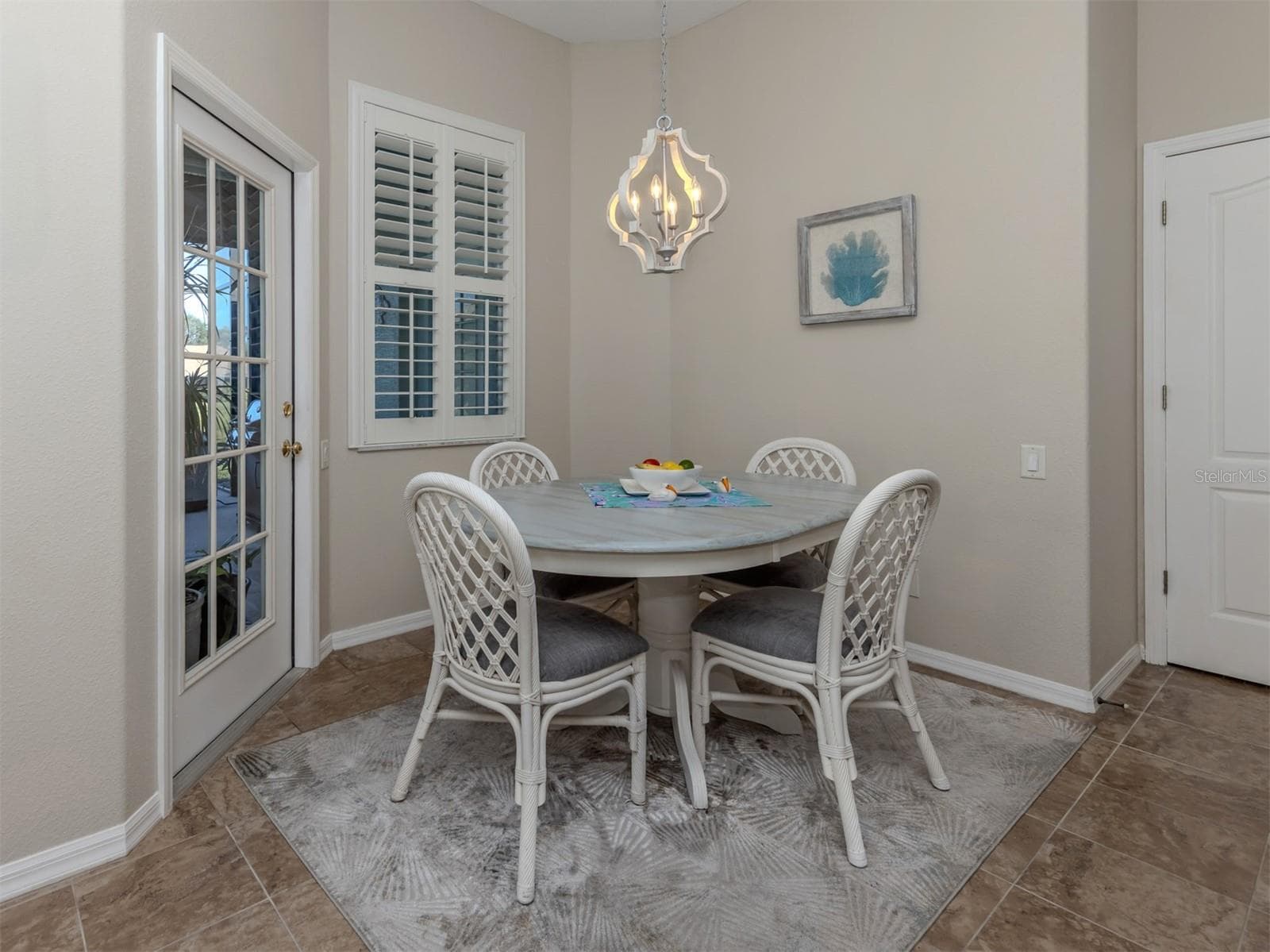 A charming breakfast nook with a delightful view! The perfect little spot to enjoy your morning coffee or a casual meal while overlooking the extended lanai and peaceful lake views beyond! - 443 BERMUDA ISLES CIR, VENICE