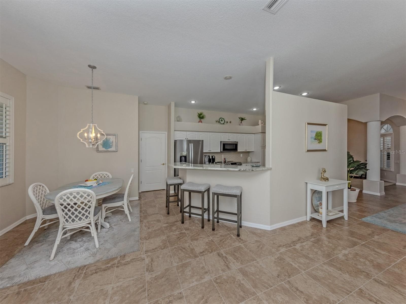 Beautifully connected and thoughtfully arranged, this inviting space brings together the kitchen, breakfast nook, and breakfast bar with comfortable seating, creating a delightful setting where everyday moments and good company come naturally! - 443 BERMUDA ISLES CIR, VENICE