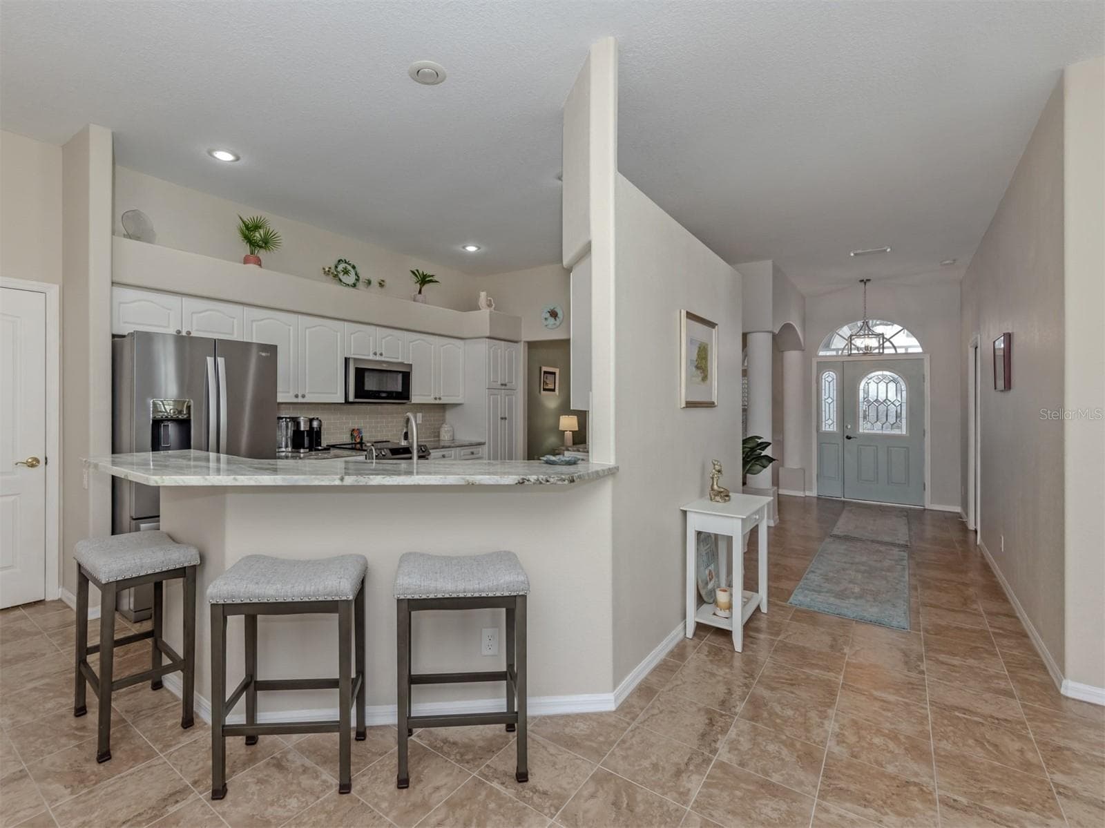 Pull up a chair and stay awhile! This inviting breakfast bar adds a casual touch to the beautifully appointed kitchen, perfect for a quick bite, a cup of coffee, or keeping the cook company! - 443 BERMUDA ISLES CIR, VENICE