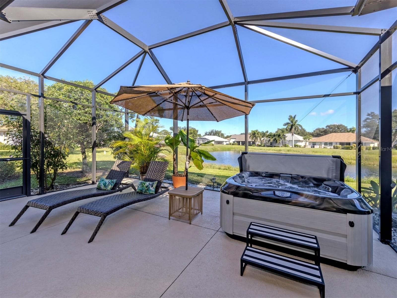 Who needs a vacation when your backyard feels like a resort? With the gentle sparkle of the lake just beyond, this fabulous outdoor living space invites you to slow down, stay awhile, and enjoy a front-row seat to the beauty of nature. Paradise looks pretty good from here! - 443 BERMUDA ISLES CIR, VENICE