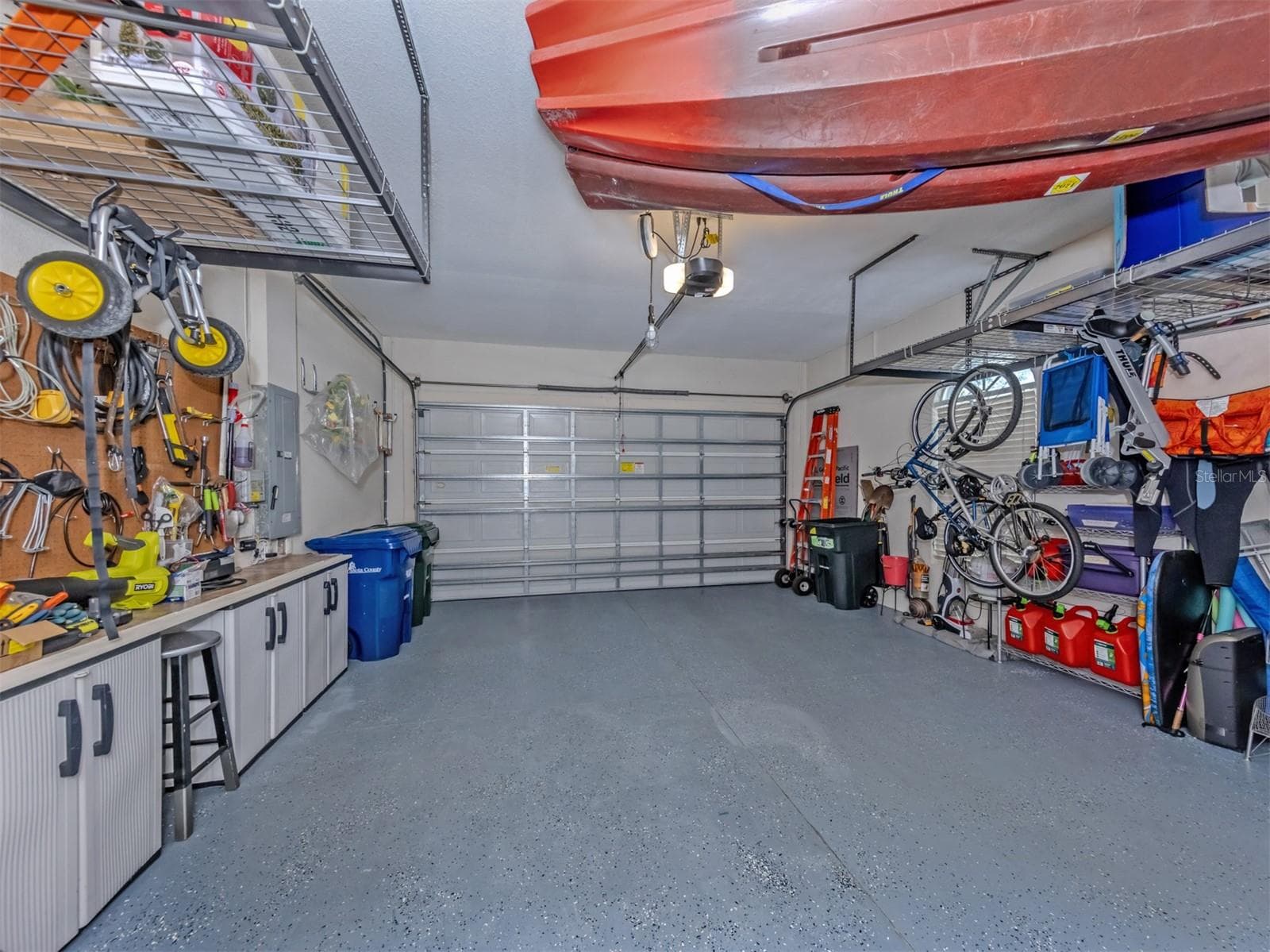 Not your ordinary garage! This oversized two-car garage is a standout, featuring sleek epoxy-coated flooring, impressive ceiling-mounted storage cubes that maximize space while keeping everything neatly organized, and a dedicated generator connection with a manual transfer switch conveniently located on the electrical panel for added peace of mind. Roomy, practical, and packed with smart features, this is a garage you'll be excited to show off! - 443 BERMUDA ISLES CIR, VENICE