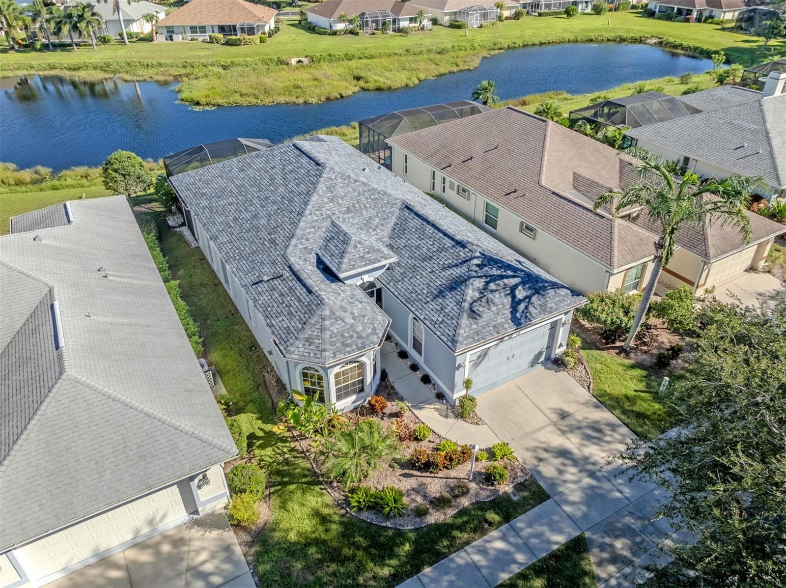 Imagine trading the hustle and bustle for a home surrounded by such lovely scenery! This bird's-eye view captures a delightful balance of neighborhood charm, waterfront beauty, and the easygoing lifestyle that makes Venice, Florida, so irresistible! - 443 BERMUDA ISLES CIR, VENICE