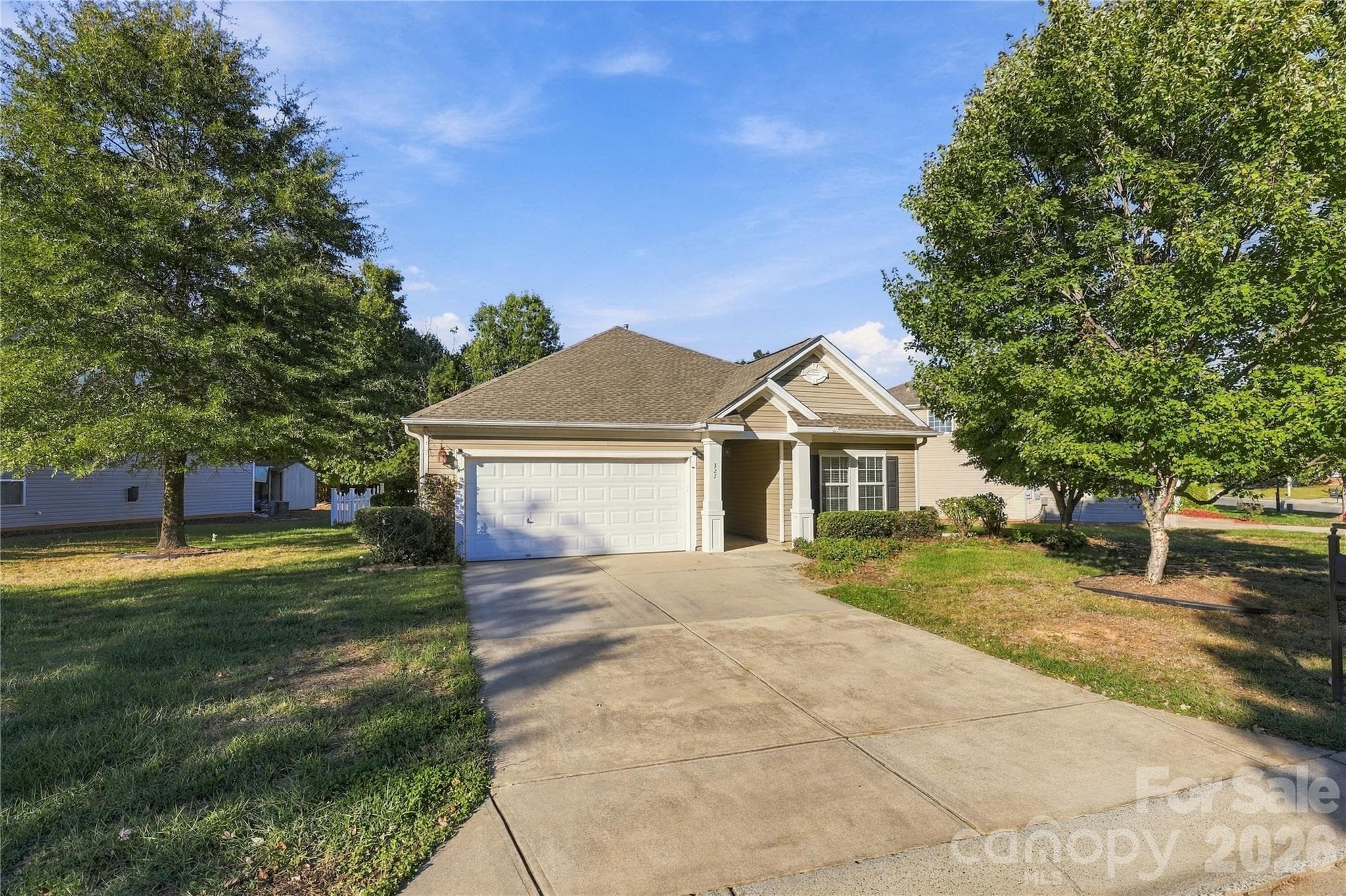 A wide driveway and a neatly landscaped front yard set a friendly first impression. - 327 Annaberg Lane, Monroe