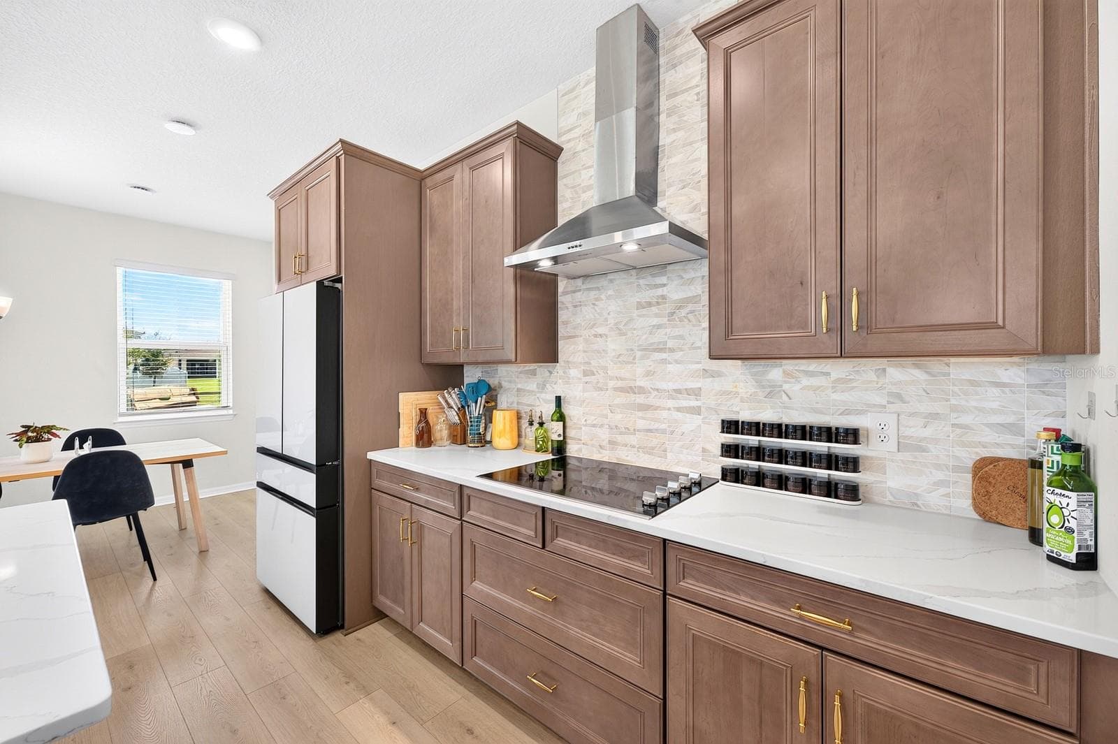 The Kitchen features solid wood cabinetry, QUARTZ COUNTERTOPS, a stylish modern backsplash and a convenient closet pantry. - 1785 PETIOLE PL, KISSIMMEE