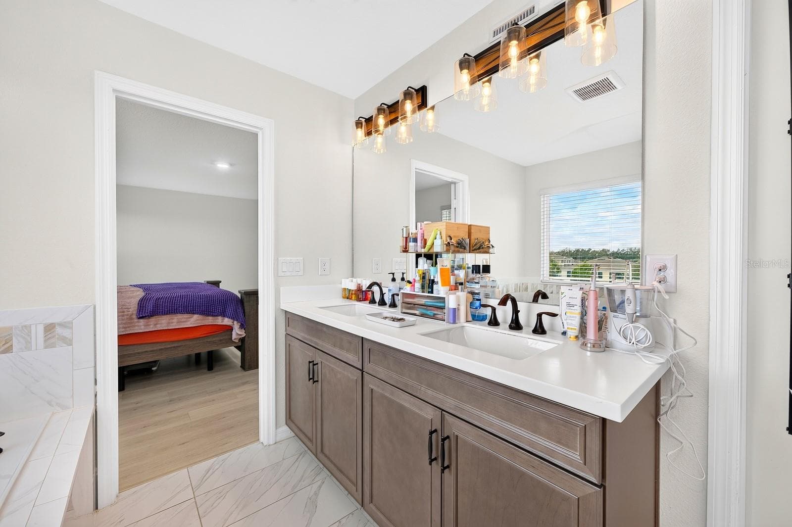 The Primary en suite Bath boasts DUAL SINKS, a GARDEN TUB, separate STEP-IN SHOWER and PRIVATE WATER CLOSET. - 1785 PETIOLE PL, KISSIMMEE