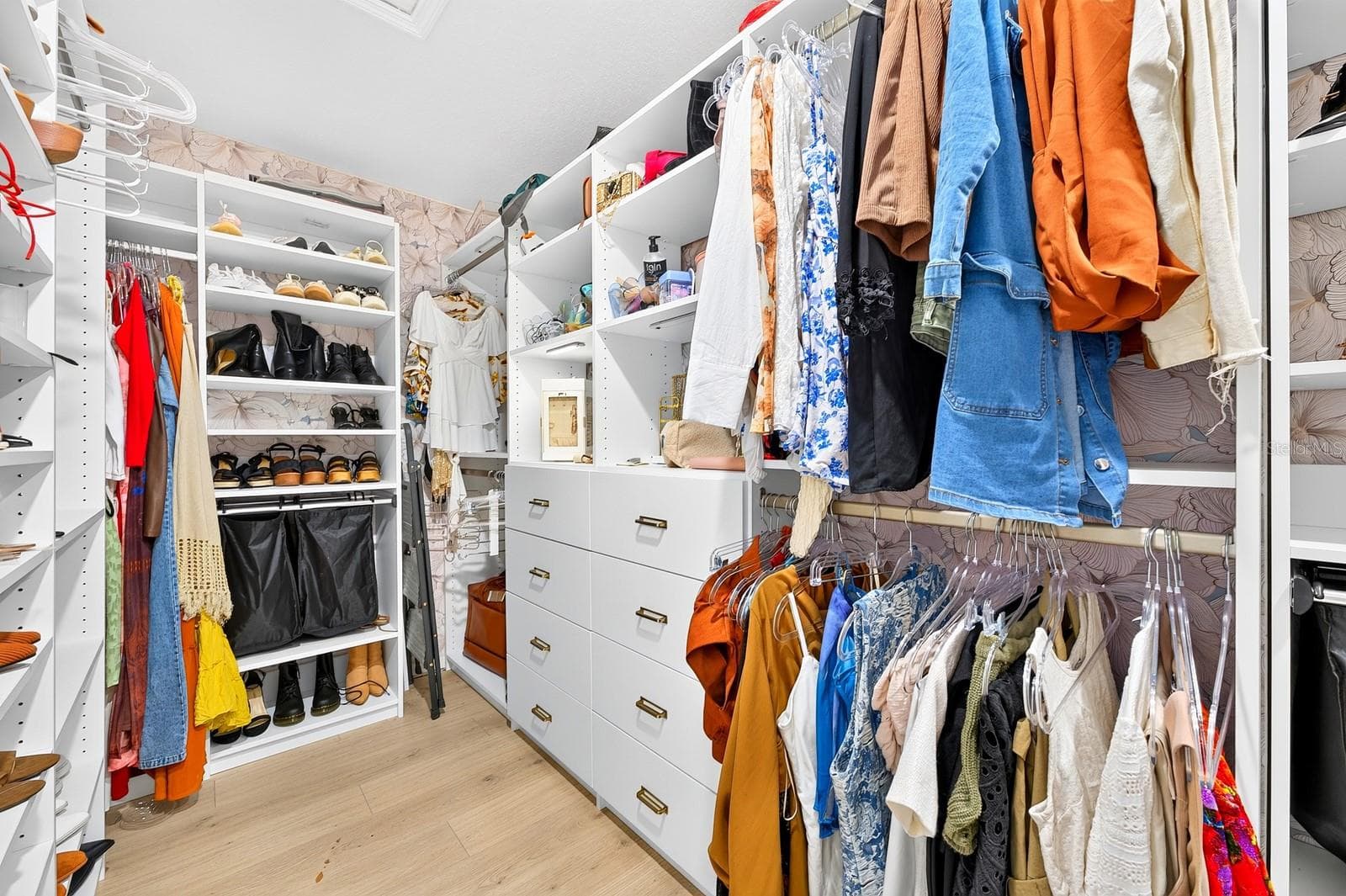 The generous walk-in closet is enhanced by a CUSTOM BUILT-IN CLOSET SYSTEM (2025), creating an organized and functional space. - 1785 PETIOLE PL, KISSIMMEE