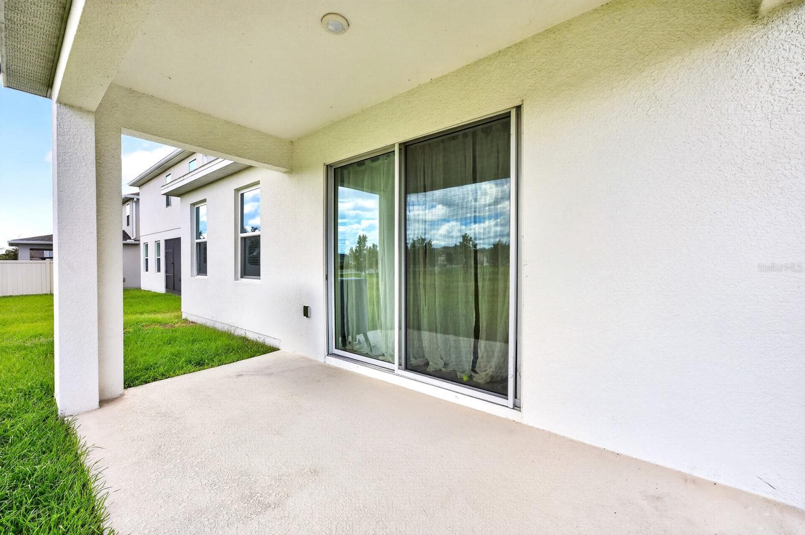 Step outside to the COVERED REAR PORCH overlooking the GENEROUS BACKYARD. - 1785 PETIOLE PL, KISSIMMEE