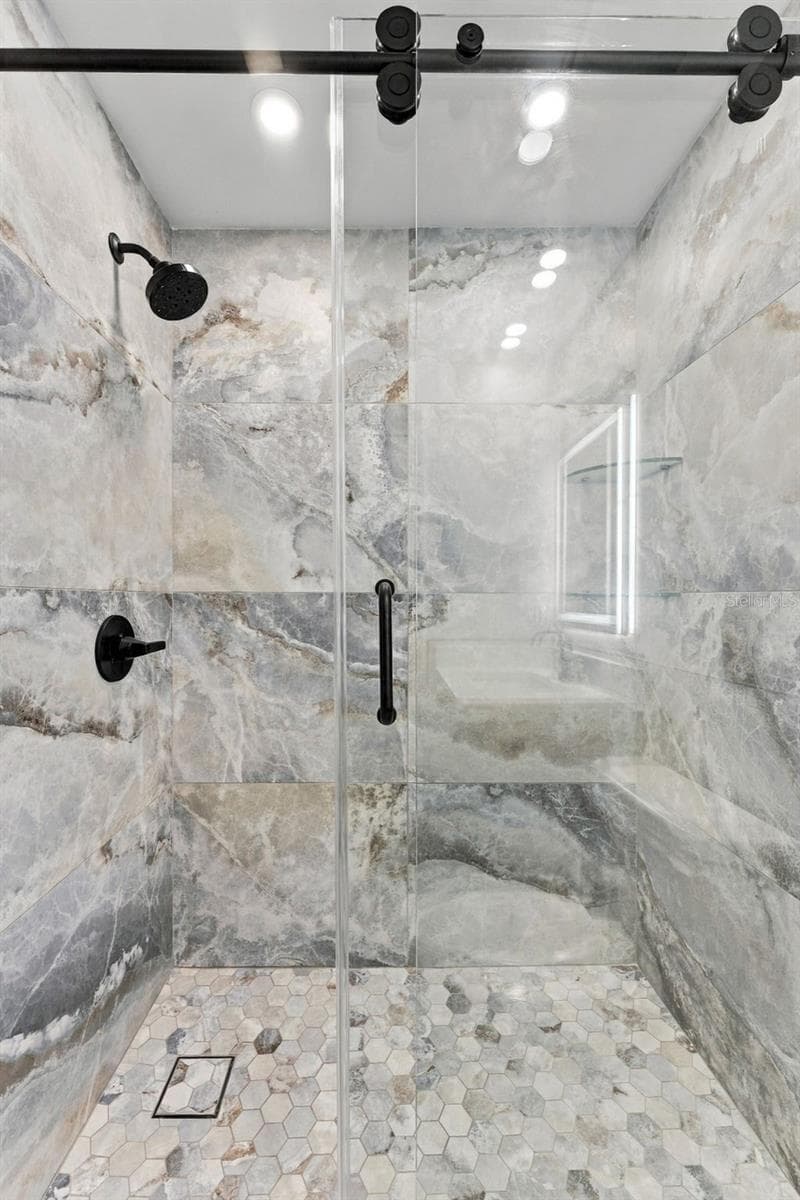 Beautifully designed hall shower with sleek glass bypass doors and modern finishes - 2650 COUNTRYSIDE BLVD #A306, CLEARWATER