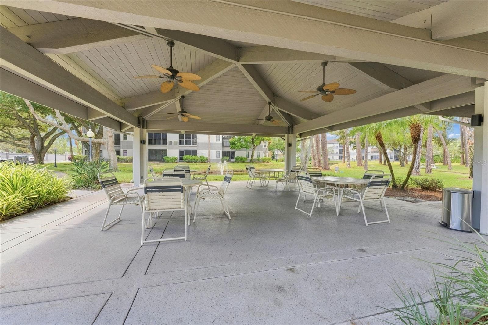 Covered poolside seating overlooking the peaceful community pond - 2650 COUNTRYSIDE BLVD #A306, CLEARWATER