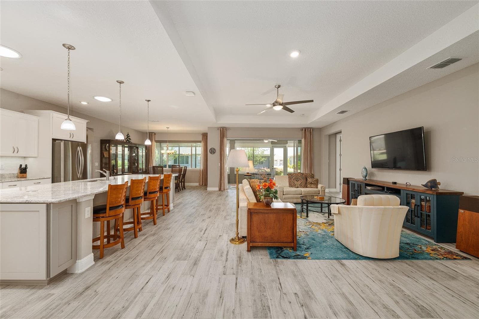Expansive open-concept design seamlessly connects the kitchen, dining area, and great room, creating an inviting space for everyday comfort, effortless entertaining, and gathering with family and friends. - 8290 SW 92ND CIR, OCALA