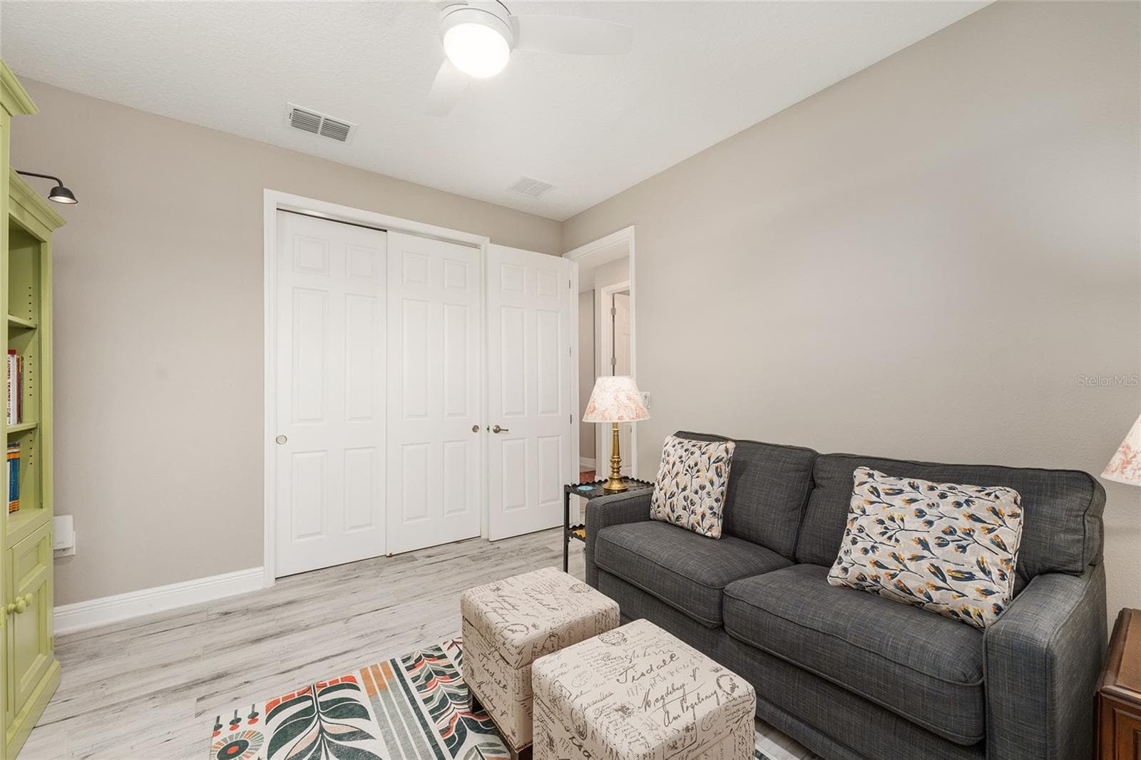 Another perspective of the third bedroom, highlighting the double sliding closet doors and generous storage space, adding functionality to this versatile room currently used as a den. - 8290 SW 92ND CIR, OCALA