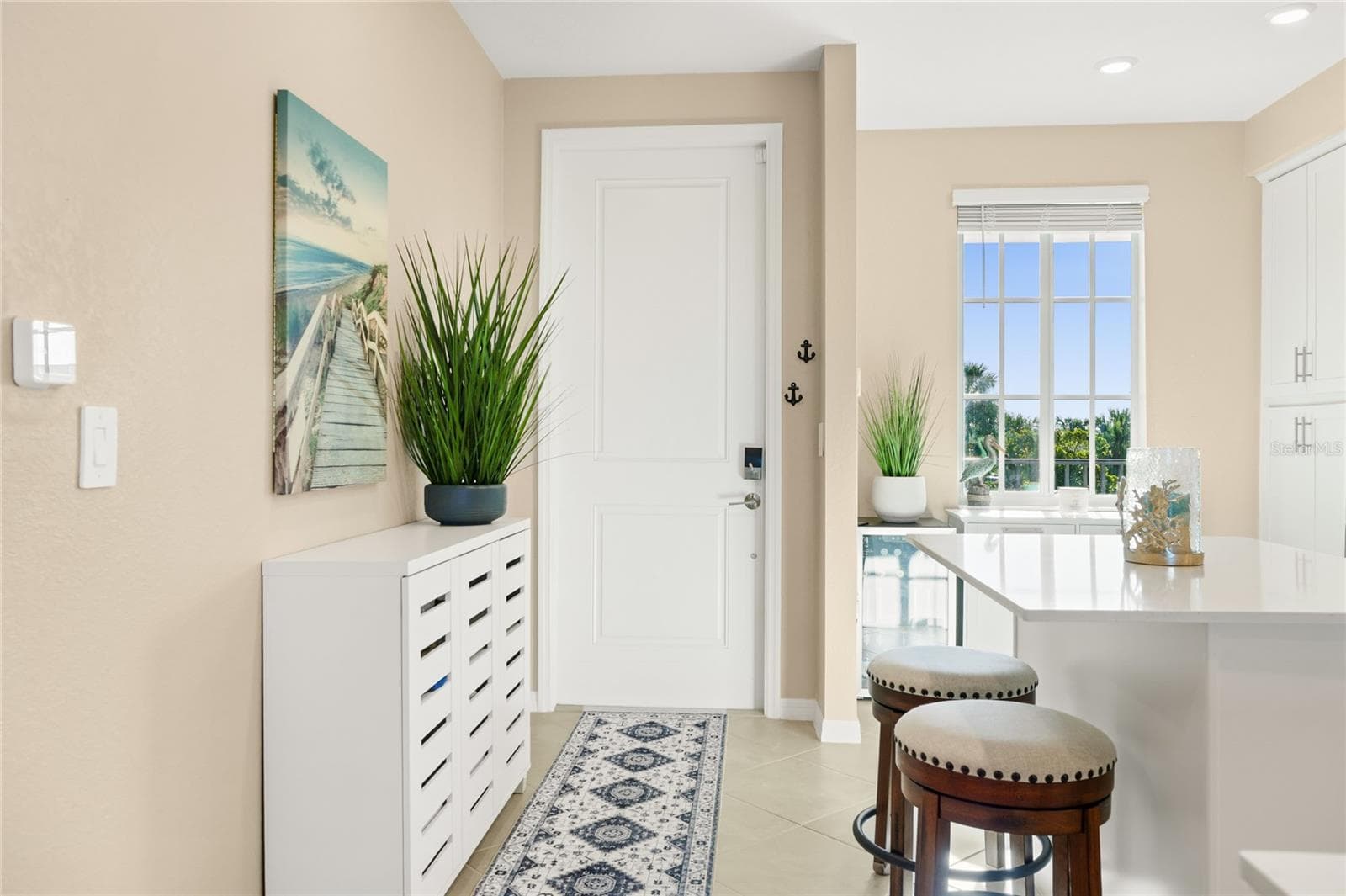 Open floor plan featuring a spacious kitchen with abundant counter space for meal preparation and ample seating, ideal for cooking and entertaining, all overlooking the living area with beautiful golf course, water, and preserve views. - 17565 OPAL SAND DR #204, VENICE
