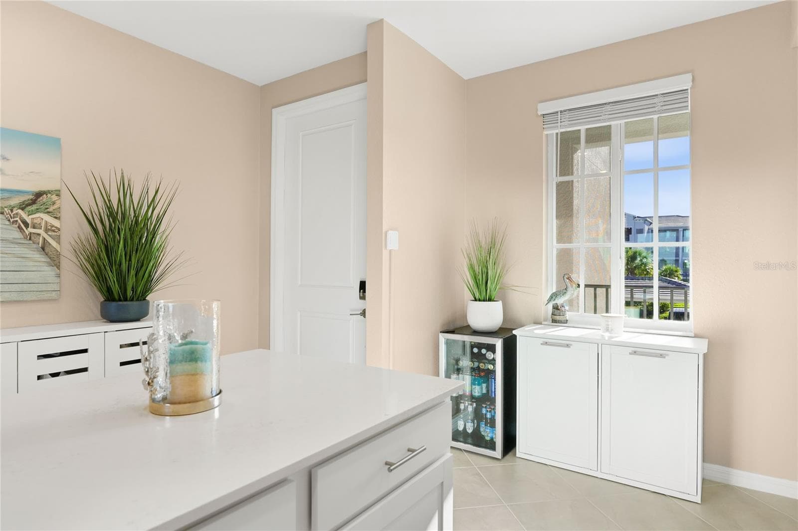 Open floor plan featuring a spacious kitchen with abundant counter space for meal preparation and ample seating, ideal for cooking and entertaining, all overlooking the living area with beautiful golf course, water, and preserve views. - 17565 OPAL SAND DR #204, VENICE