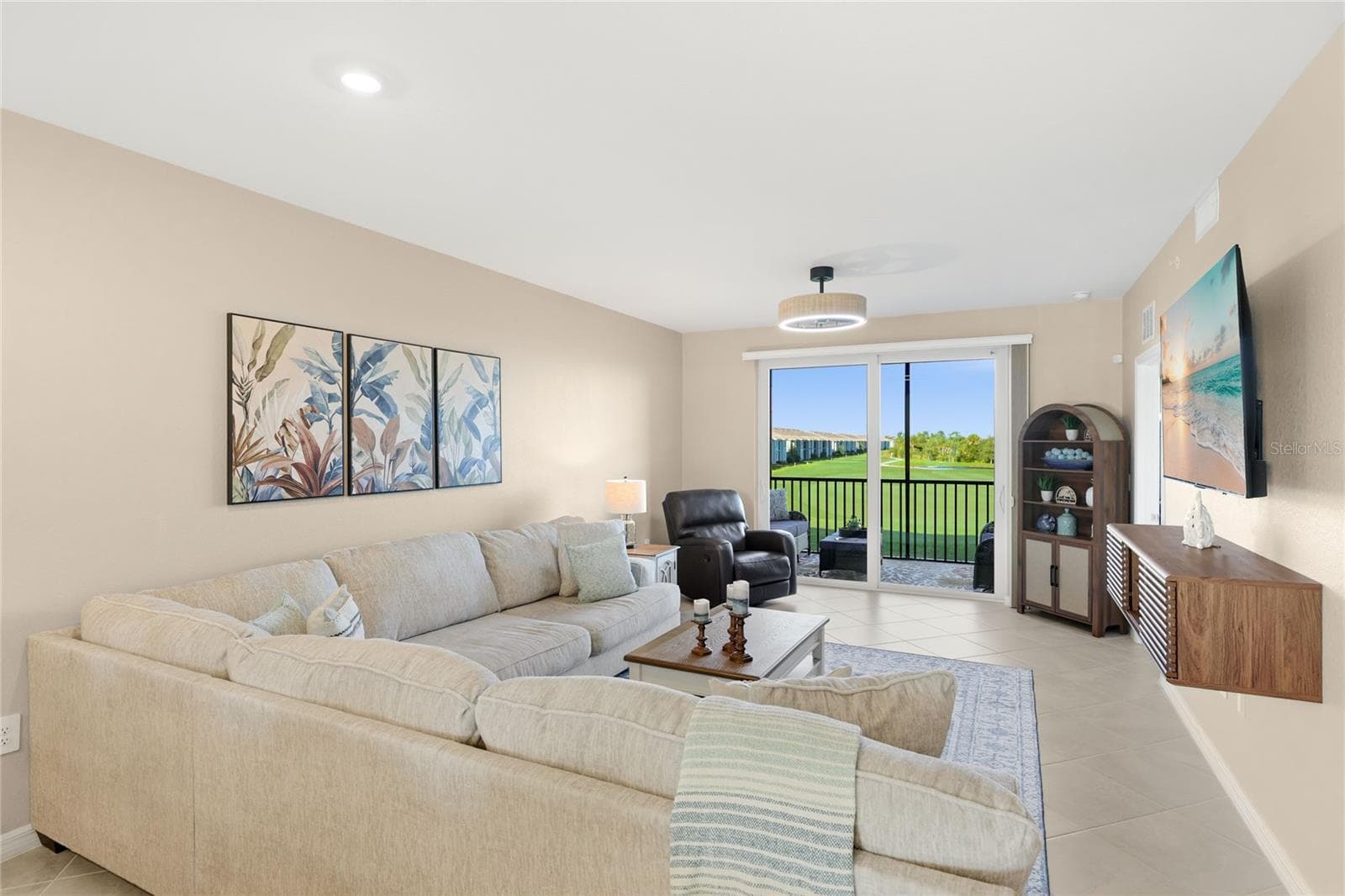 Living Room overlooking the spacious Lanai with beautiful golf course, water, and preserve views. - 17565 OPAL SAND DR #204, VENICE