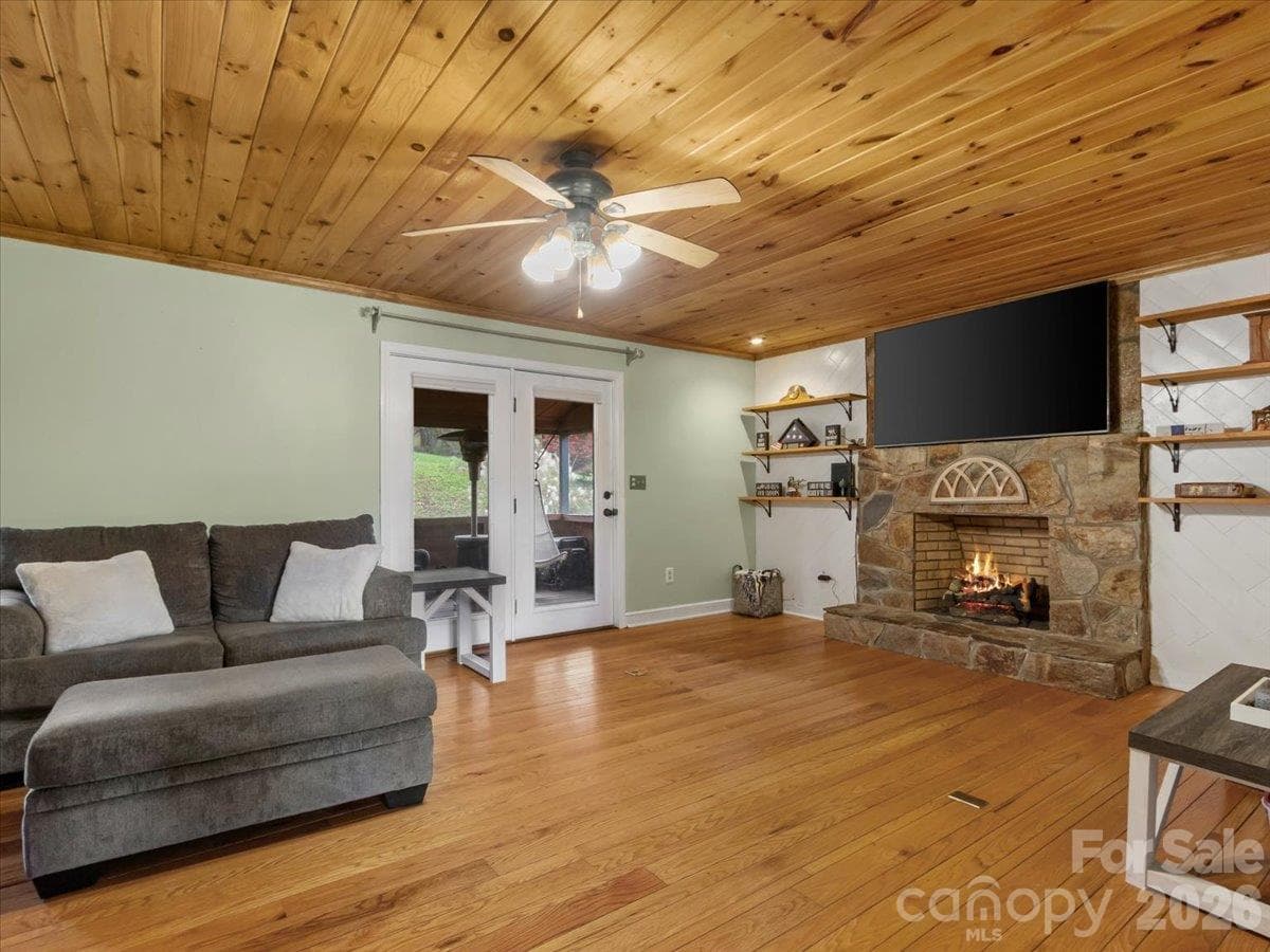 Living room with gas fireplace and doorway onto screened in porch - 179 River Walk Drive, Burnsville