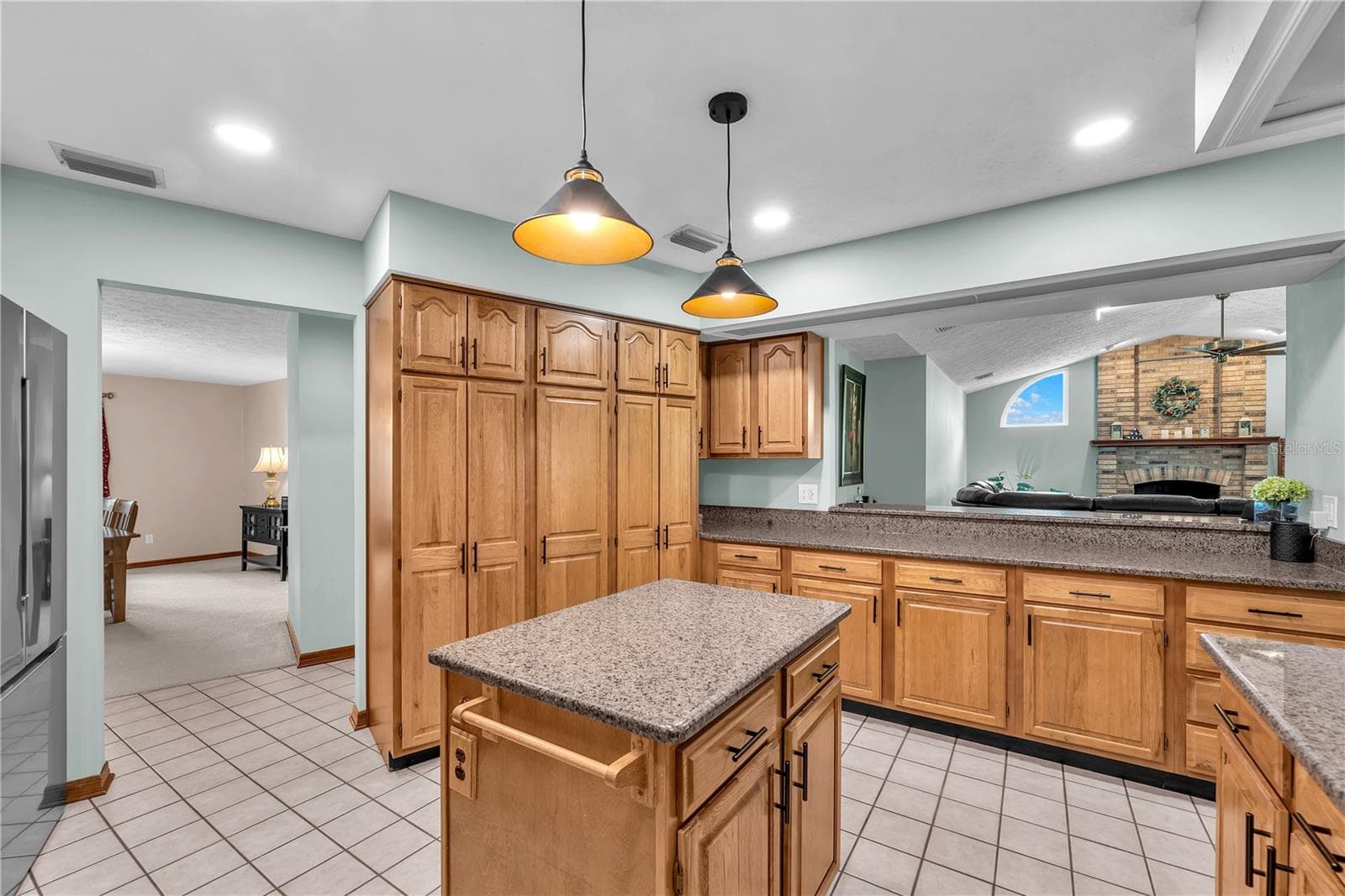 The kitchen has a breakfast bar connection to the family room to keep the conversations flowing. - 2421 OAK LANDING DR, BRANDON