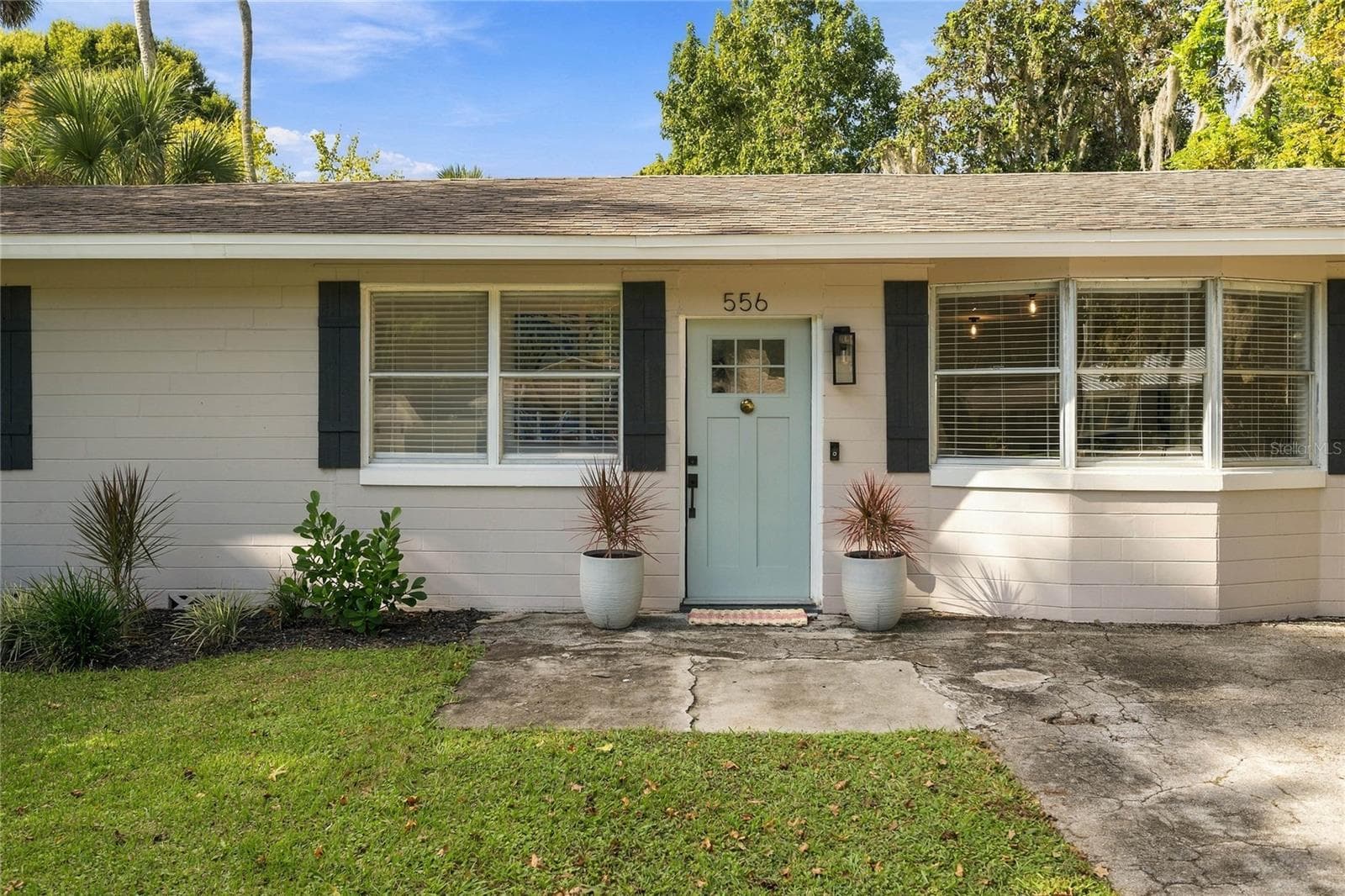lovely landscaped front and pretty new door and sidelights - 556 OLIVER DR, NEW SMYRNA BEACH