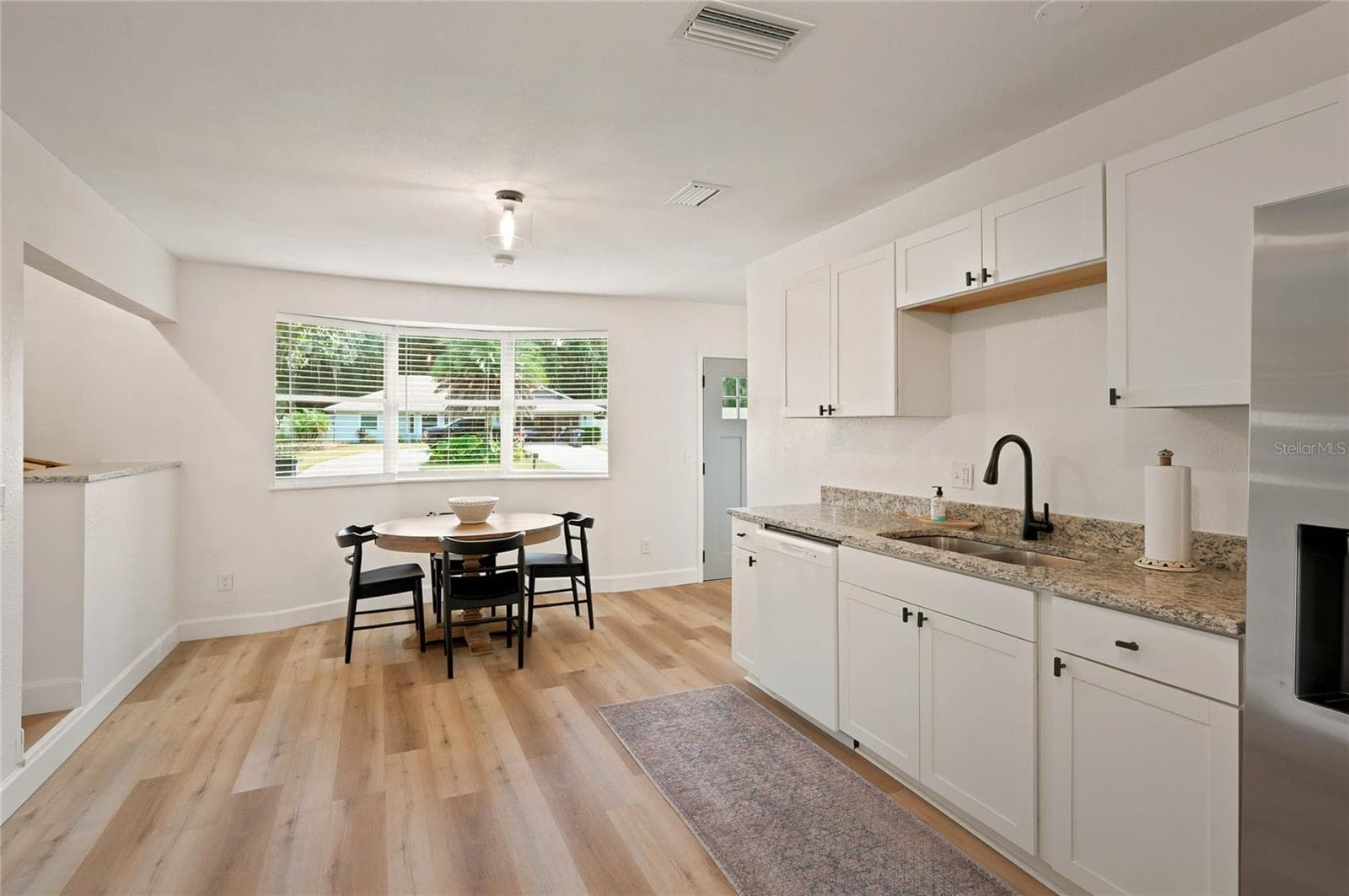 kitchen to dining and bay window to front - 556 OLIVER DR, NEW SMYRNA BEACH