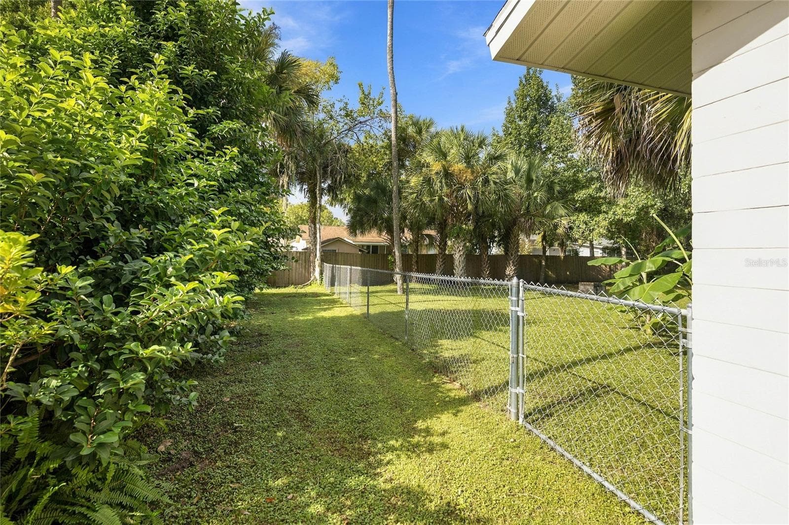 left side yard, has chain link fence and gate - 556 OLIVER DR, NEW SMYRNA BEACH