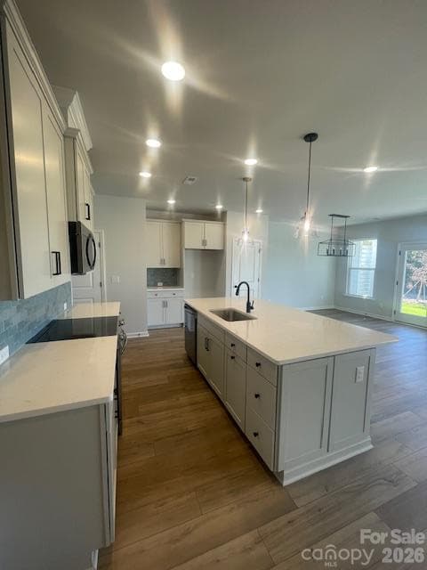 Kitchen features Frost color cabinets, quartz countertops. Tiled backsplash. LVP flooring throughout the main level - 257 Alluvium Lane, Waxhaw