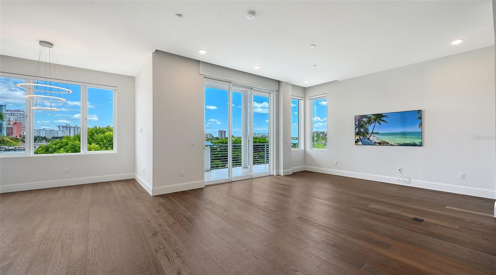 Living and dining area and 10 ft sliders and large picture windows for natural light - 609 GOLDEN GATE PT #301, SARASOTA