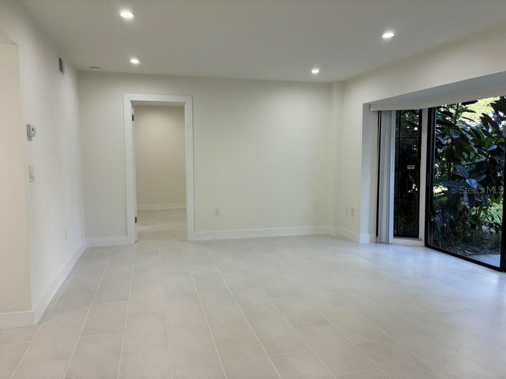 Living room and porch on left hand side - 5999 VILLAGE CIR #990, ORLANDO