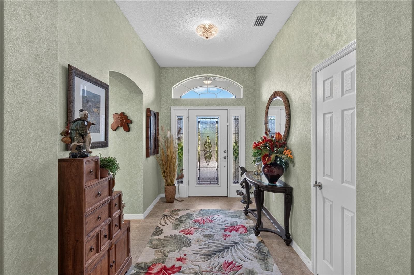 Entry way features lead glass front door, two side lights, transom window, and closet. - 3665 VALLEYBROOK WAY, THE VILLAGES