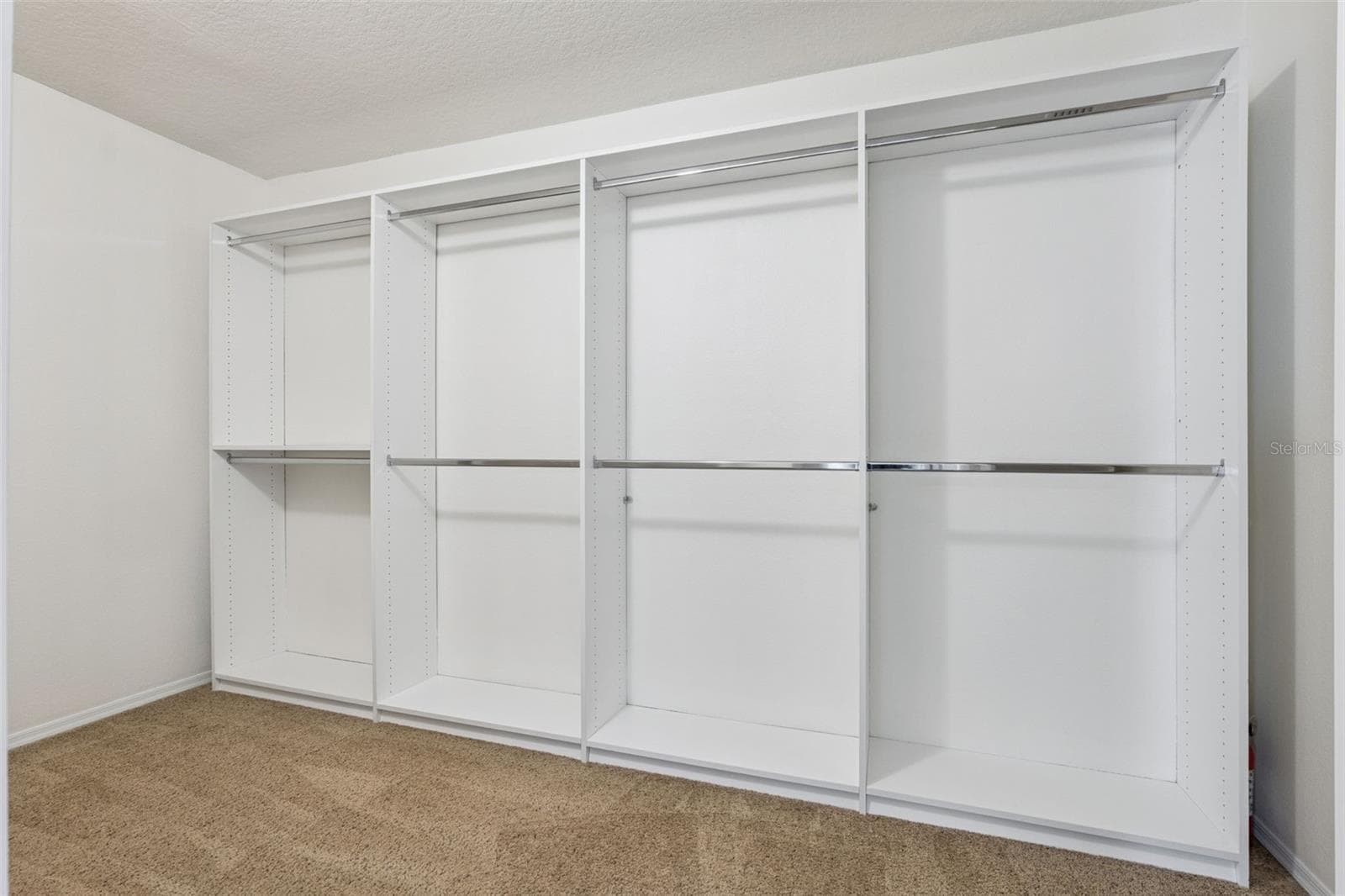 Primary suite walk-in closet featuring custom-built-in organization system - 13612 LARANJA ST, CLERMONT