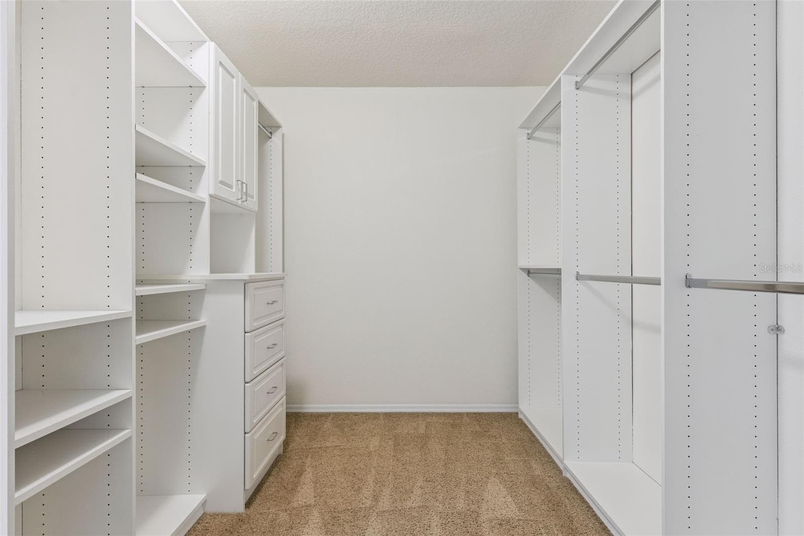 Primary suite walk-in closet featuring custom-built-in organization system - 13612 LARANJA ST, CLERMONT