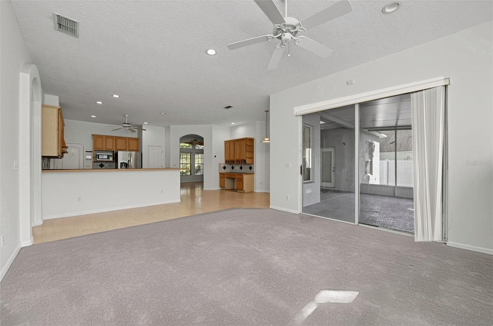 OPEN CONCEPT BETWEEN FAMILY ROOM AND KITCHEN. SLIDING DOORS ACCESS SCREENED LANAI. - 13838 RIVERPATH GROVE DR, ORLANDO
