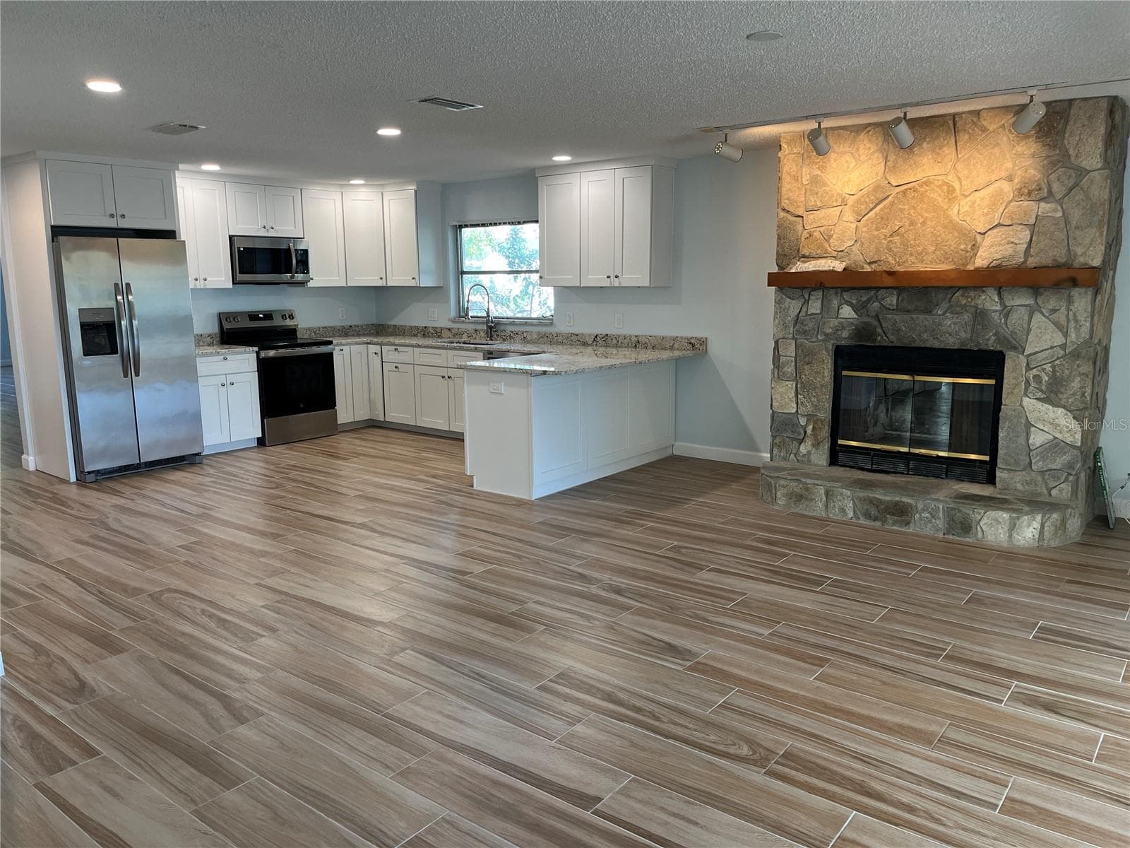 Kitchen and fireplace - 307 LA HACIENDA DR, INDIAN ROCKS BEACH