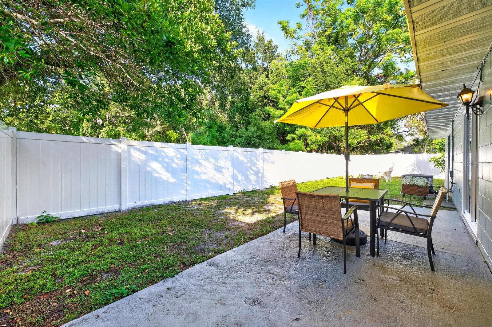 Sliding glass doors open to a SIDE PATIO, offering a lovely spot to enjoy your morning coffee or relax outdoors. - 543 HIBISCUS WAY #9C, ORLANDO