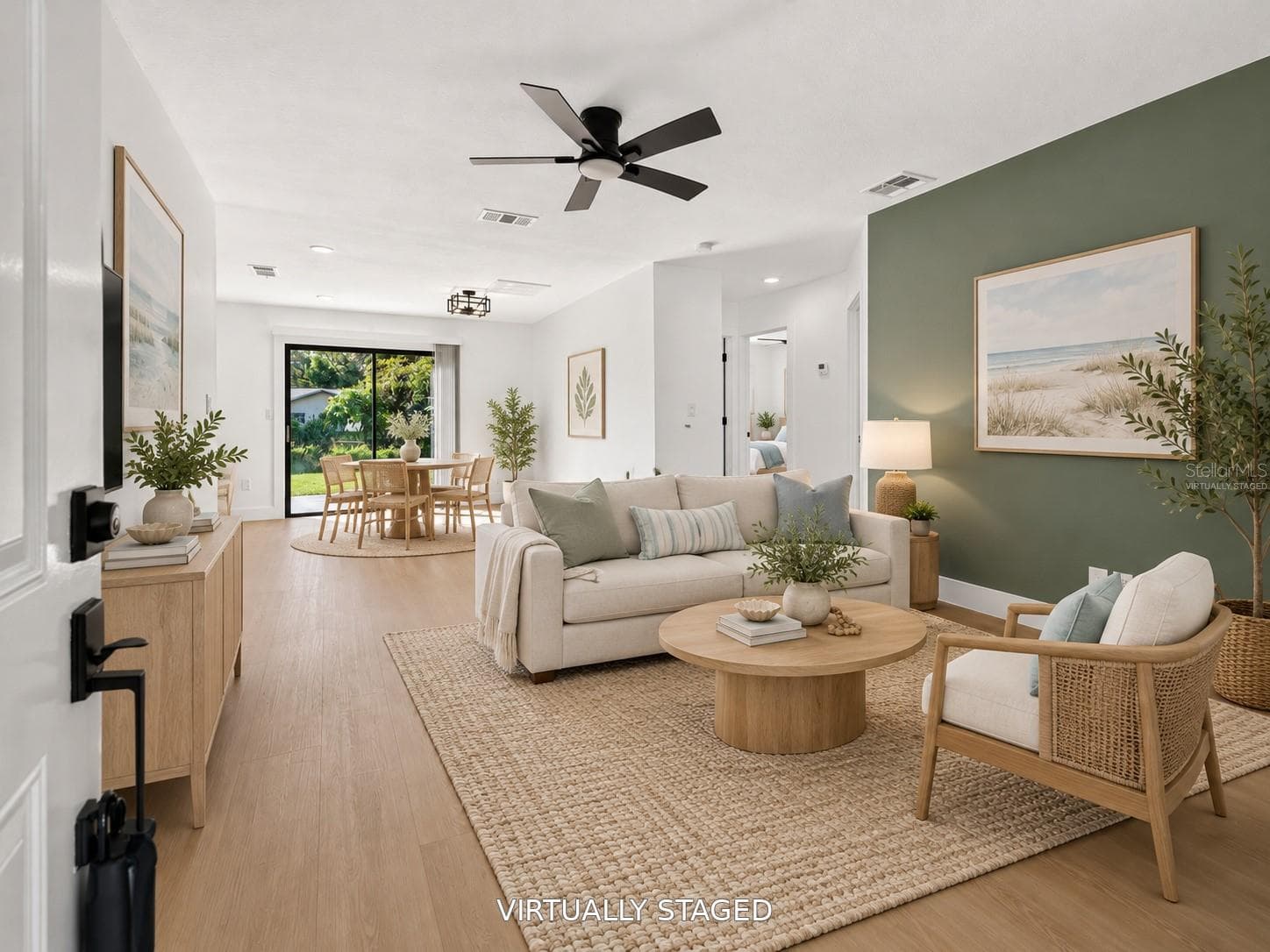 VIRTUALLY STAGED. Spacious living area featuring a modern sage green accent wall. - 16107 SEA PINES DR, HUDSON
