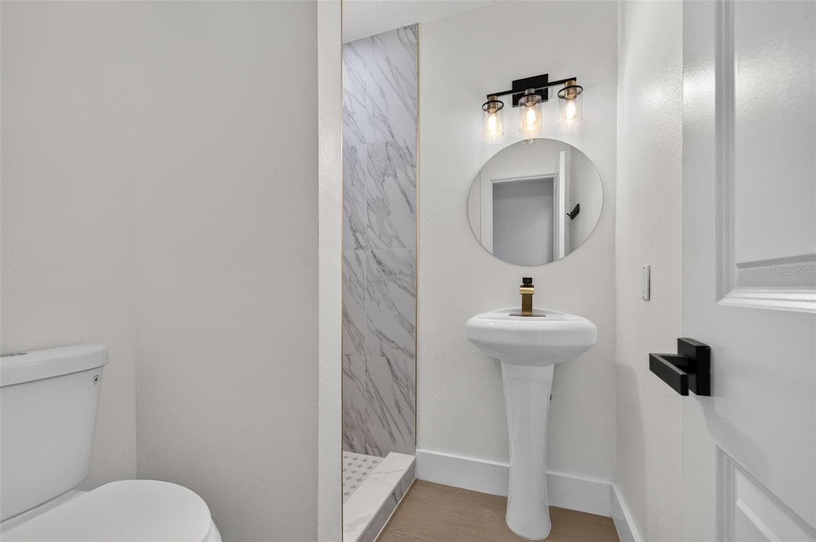 Beautifully updated ensuite bathroom featuring modern finishes and elegant gold accents. - 16107 SEA PINES DR, HUDSON