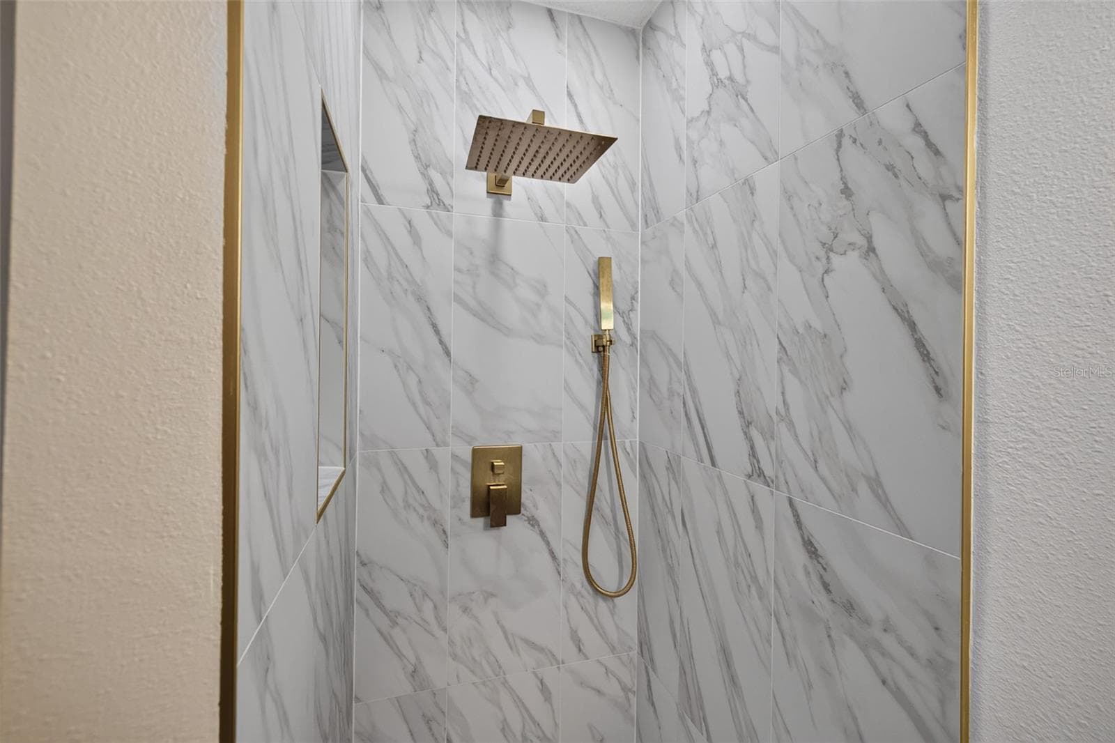 Step-in shower showcases beautiful new tile and stylish gold fixtures. - 16107 SEA PINES DR, HUDSON